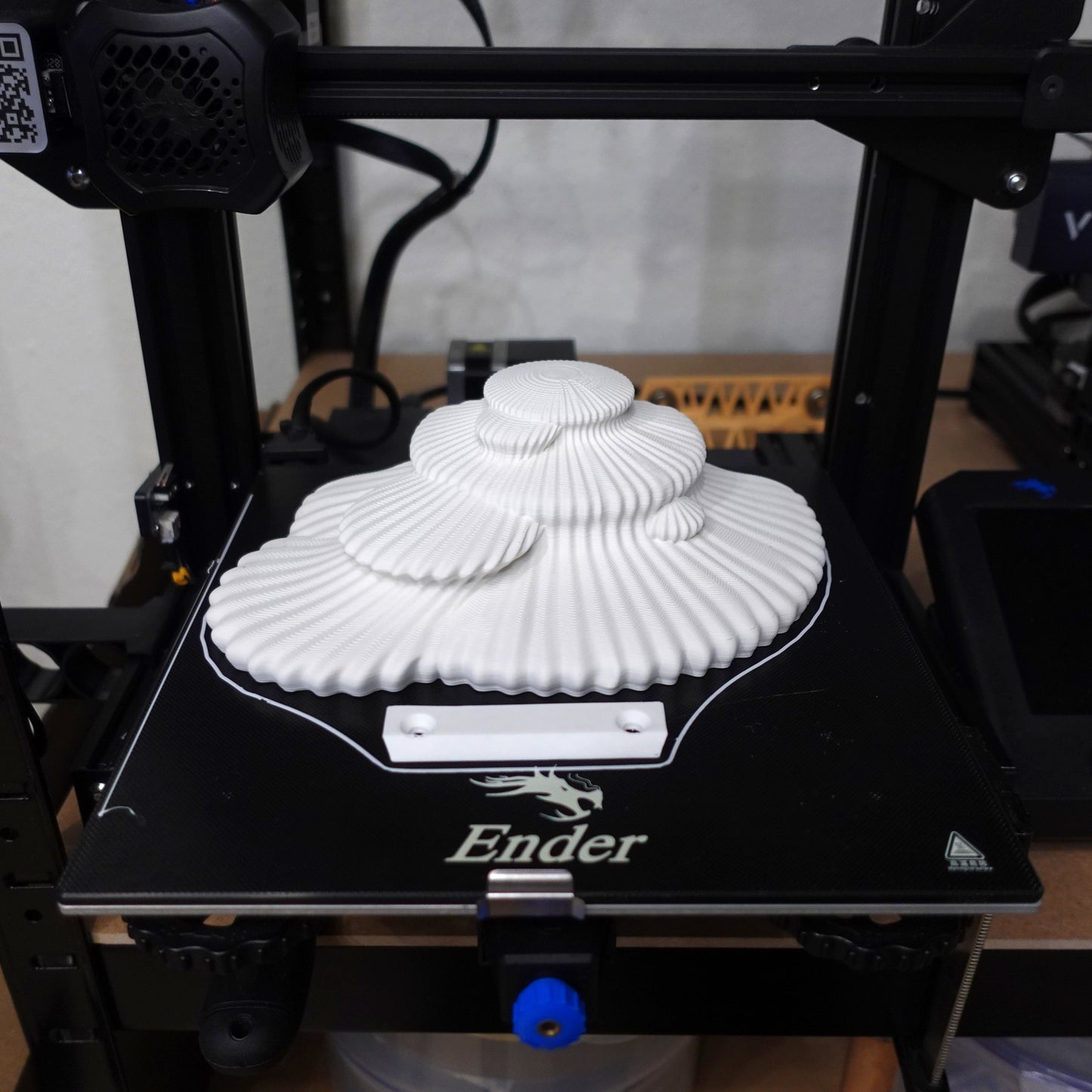 3D printed white floating shelf in progress on a 3D printer, illustrating the modern manufacturing method behind the Tinder fungus design.