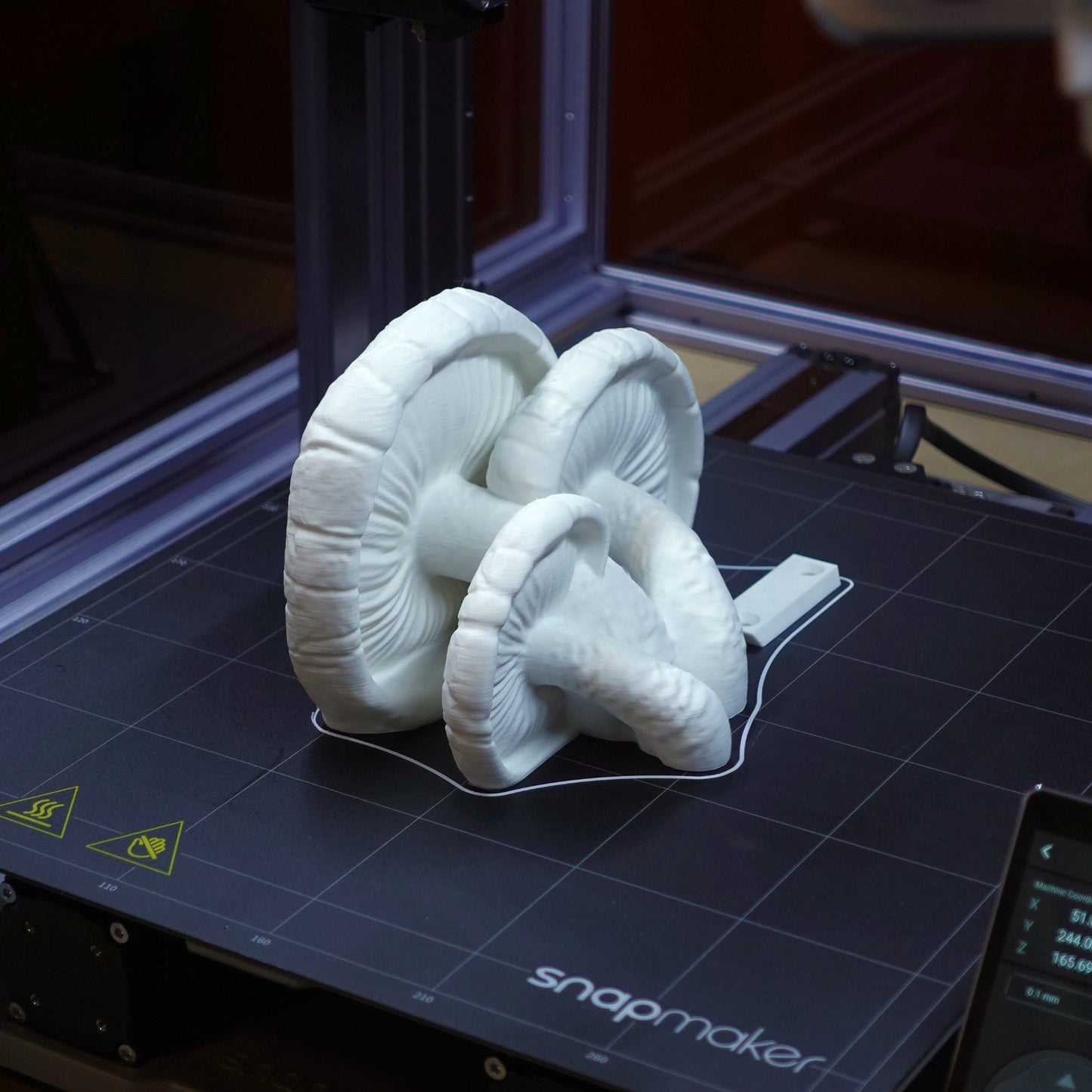 3D printed white Edodes Fungus floating shelves in production, showcasing the intricate design and textures on a printing platform.