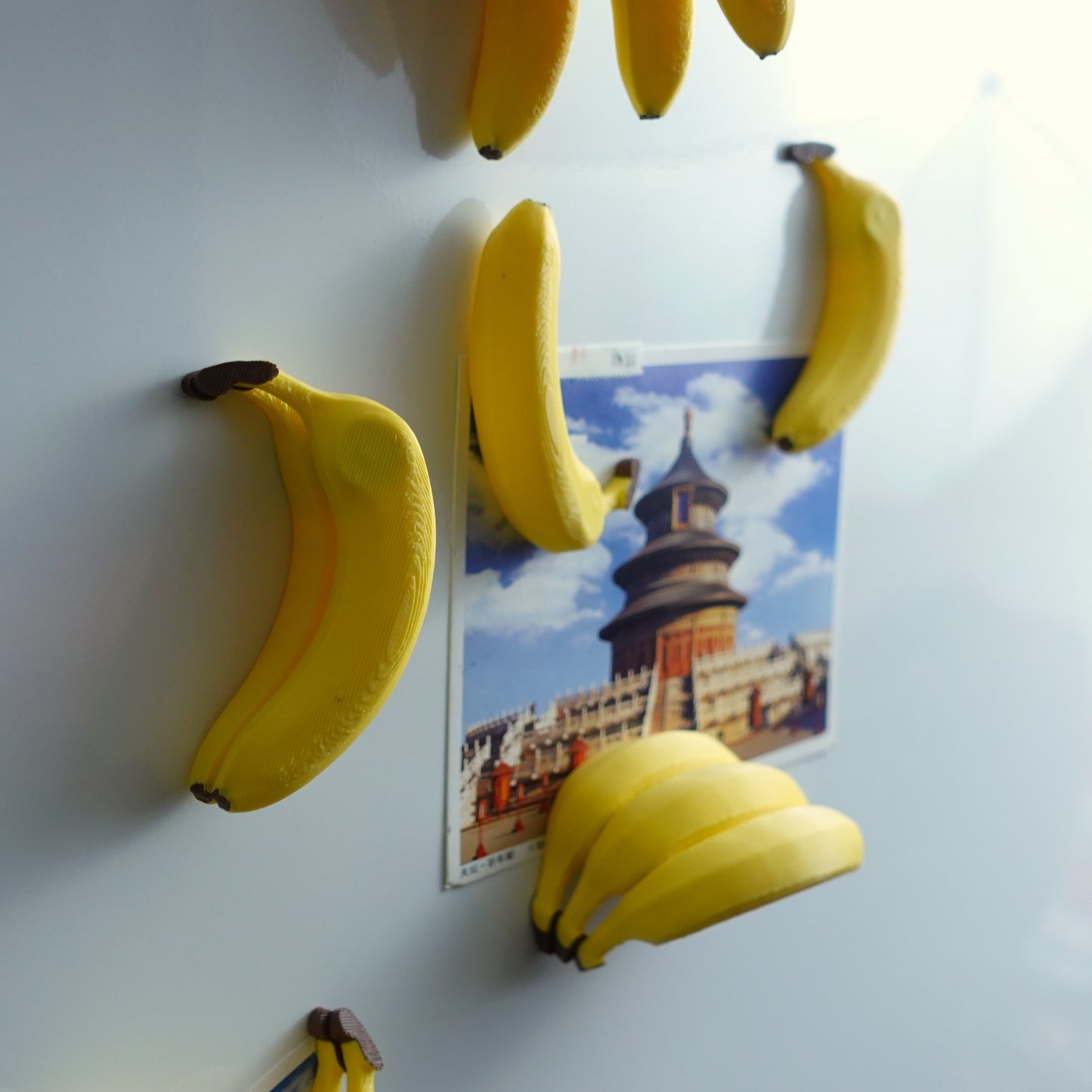 Creative arrangement of Stacked Banana Fridge Magnets - Set of 6 on a white background, expertly connecting to showcase their playful and functional design.