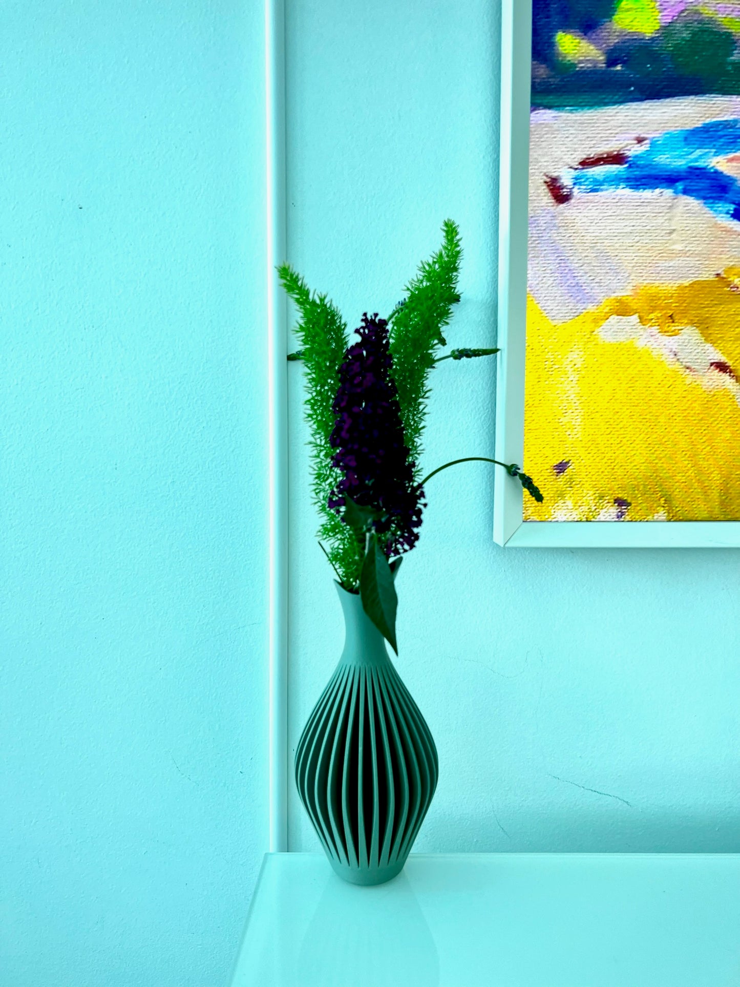 Stylish teal wall vase featuring a simple, modern design with lush floral display.
