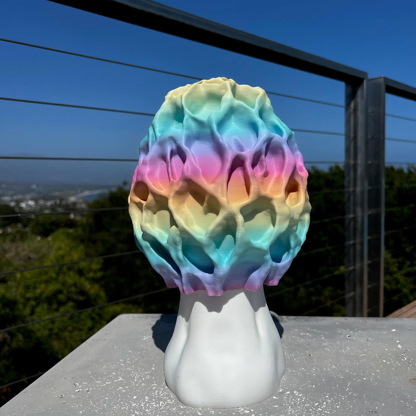 Morel-shaped lamp with dynamic colors, resting on a minimalistic surface near natural light.