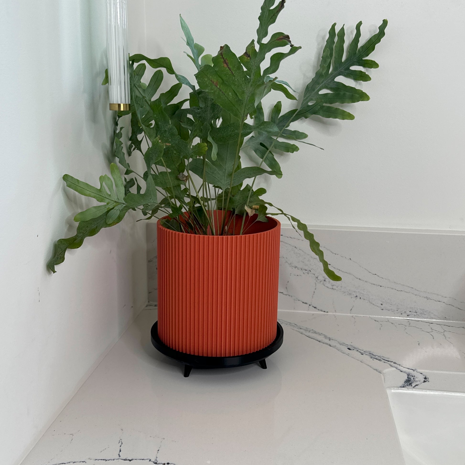 Decorative ribbed flower pot – Contemporary planter with a unique ribbed texture, crafted in luxurious marble colors. Comes with a stylish stand for added elevation and elegance.