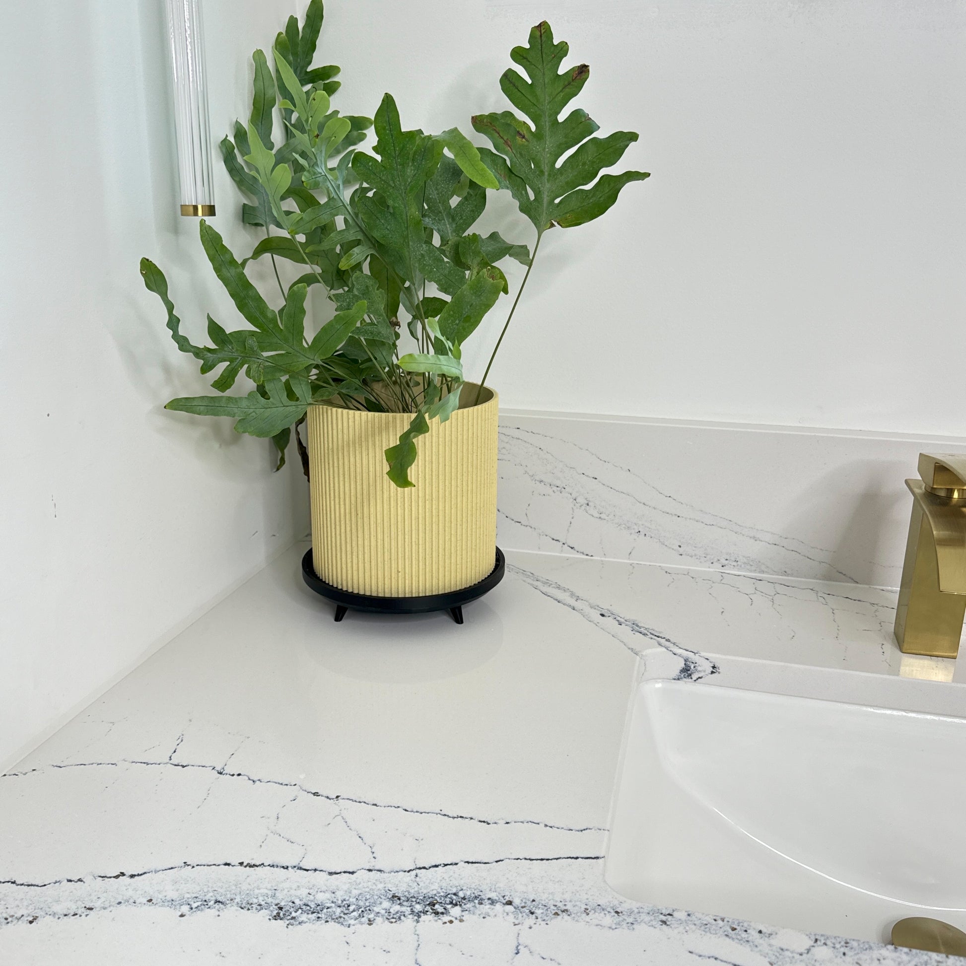 Elegant indoor planter with stand – A sleek and modern ceramic planter featuring a ribbed design and rich marble tones, complete with a minimalist black stand for a sophisticated look.