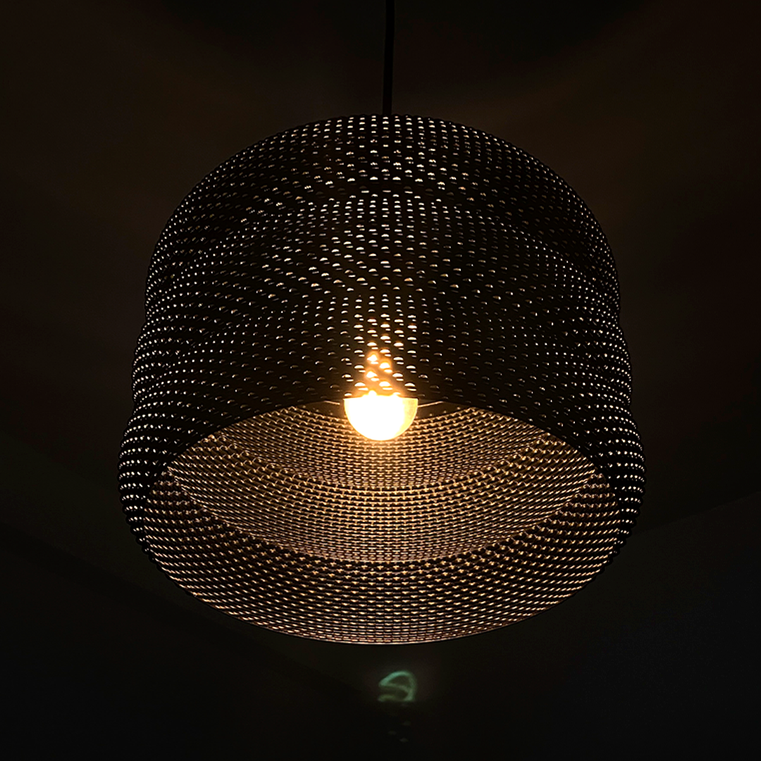 Mara Lampshade glowing warmly in a dimly lit room, showcasing its unique design and captivating light effects.