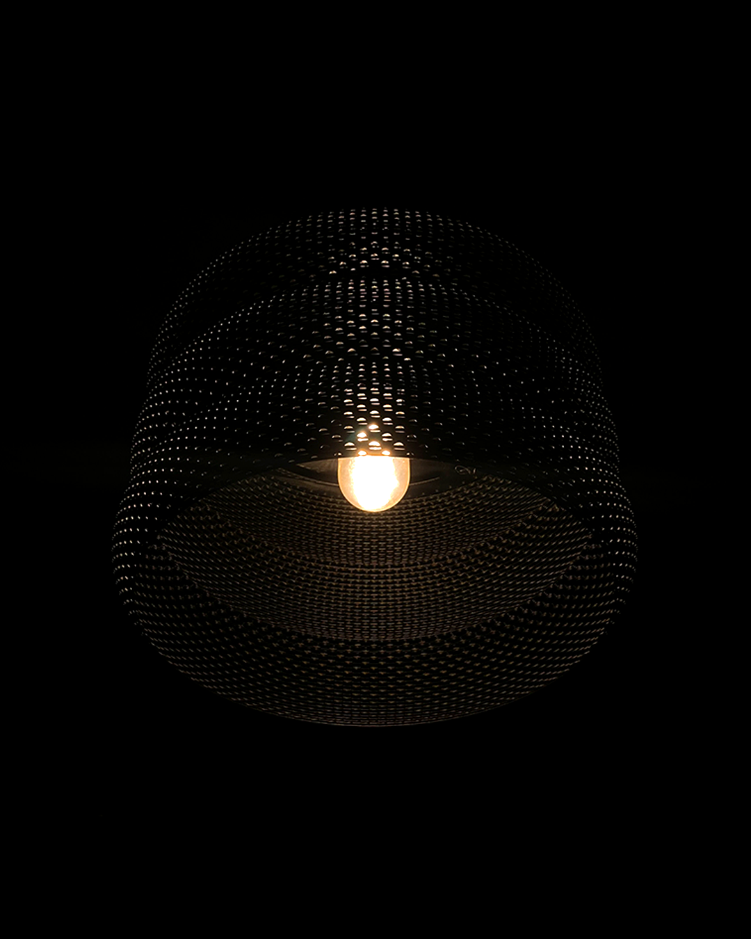 Mara Lampshade hanging elegantly in a dark setting, highlighting its stylish design and warm glowing light.