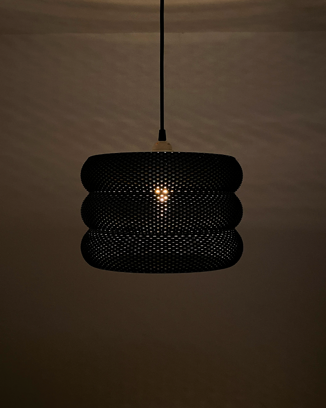 Mara Lampshade providing artistic illumination in a shadowy environment, accentuating its RippleMesh texture.