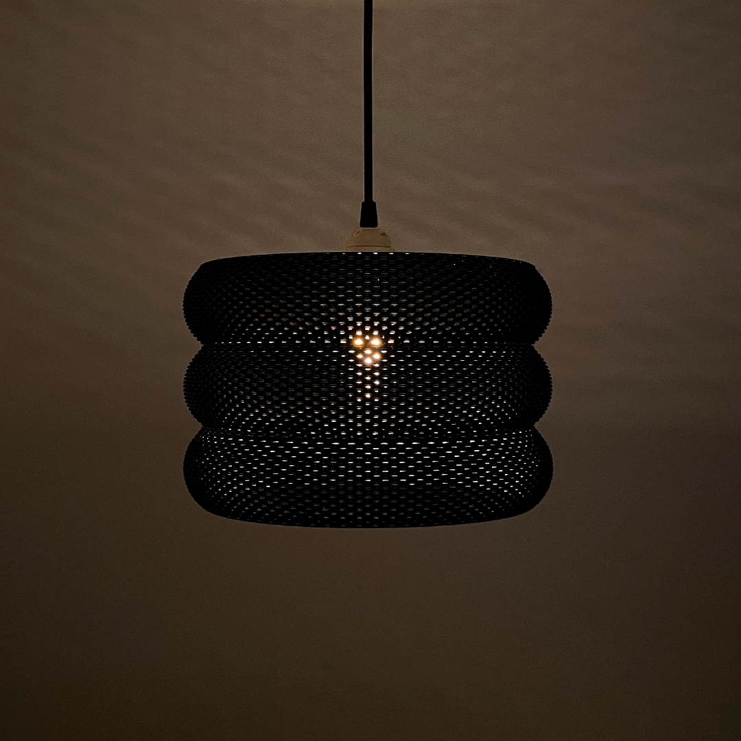 Mara Lampshade providing artistic illumination in a shadowy environment, accentuating its RippleMesh texture.