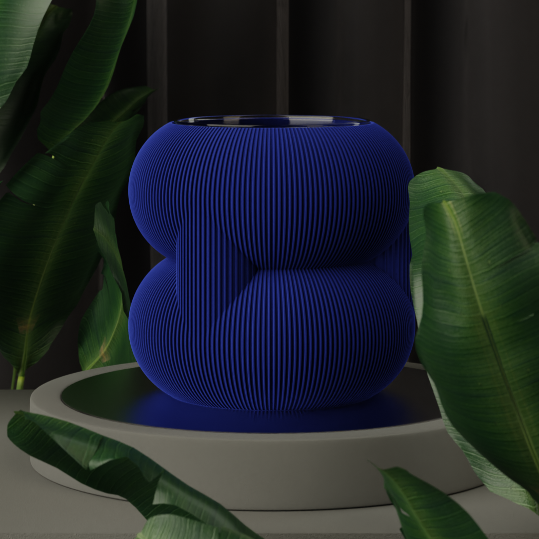 A bold blue rounded stacked planter displayed on a sleek surface, surrounded by green foliage, adding a contemporary touch to interior gardening.