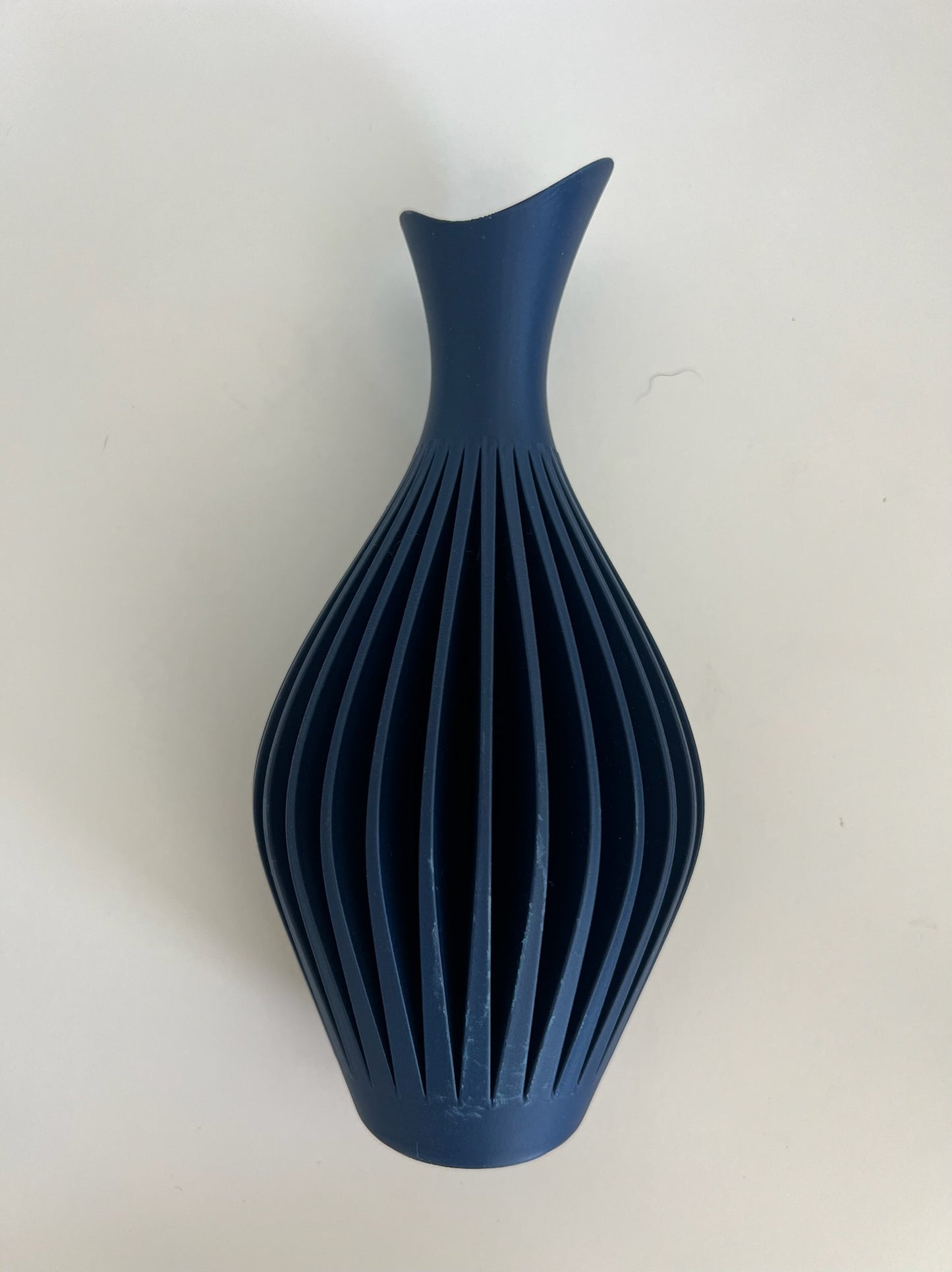 Striking navy blue wall vase showcasing floral decor, adding style to a minimalist space.