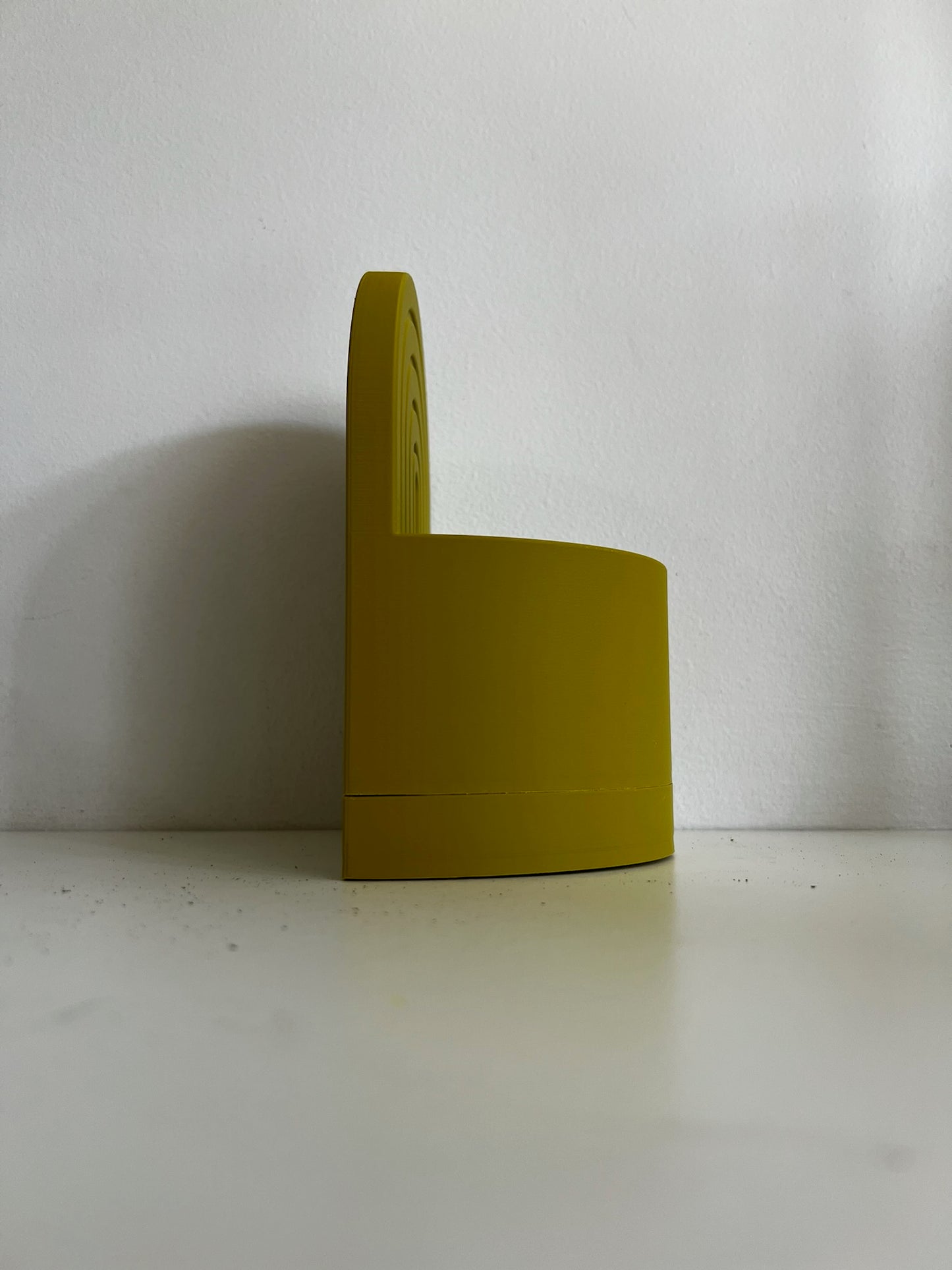 Side view of a cheerful yellow arch bookend planter showcasing its sleek design, placed on a simple white surface.
