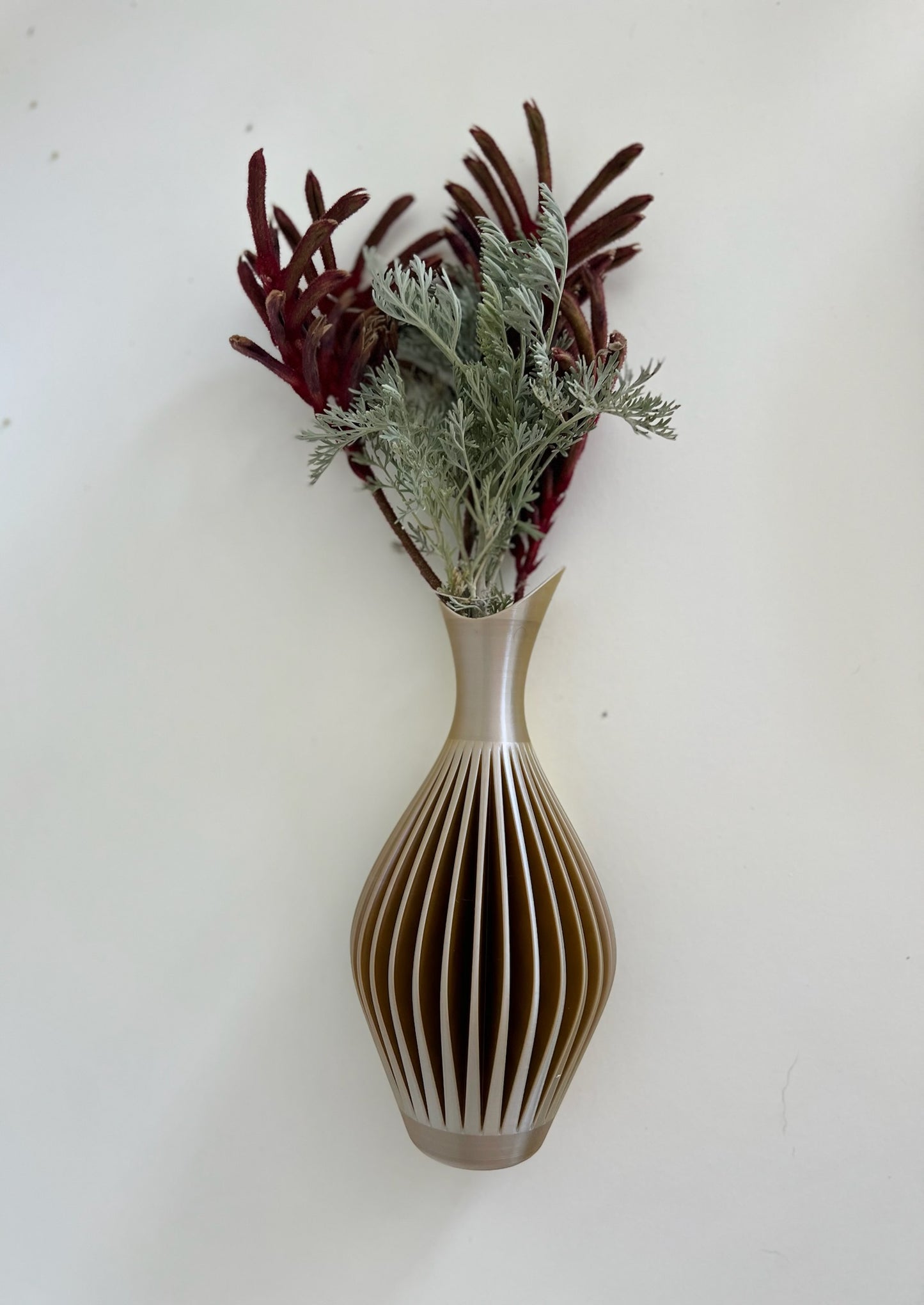 Light beige wall vase beautifully arranged with flowers, designed as a functional art piece.