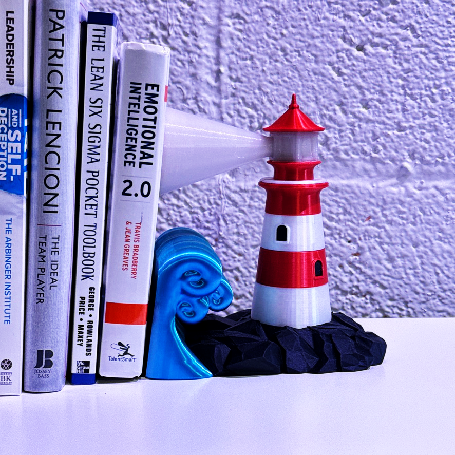 Lighthouse bookend placed beside books on a shelf, displaying its unique design and vibrant colors.