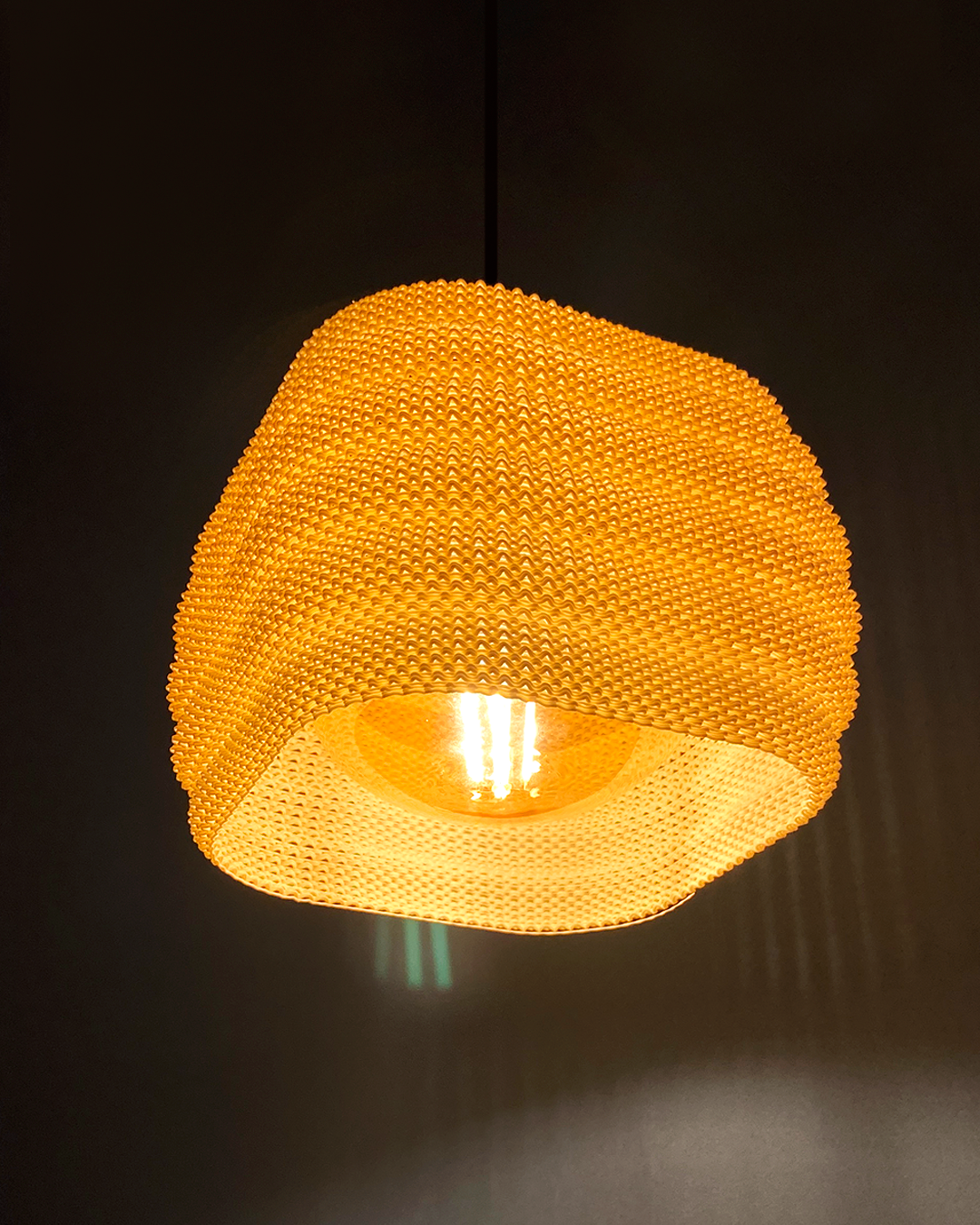 Daira Lampshade featuring round edges in a warm orange hue, casting inviting light and stylish shadows.
