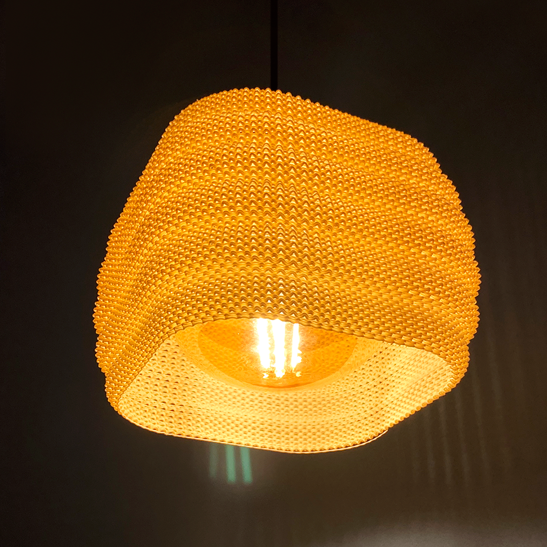 Daira Lampshade featuring round edges in a warm orange hue, casting inviting light and stylish shadows.