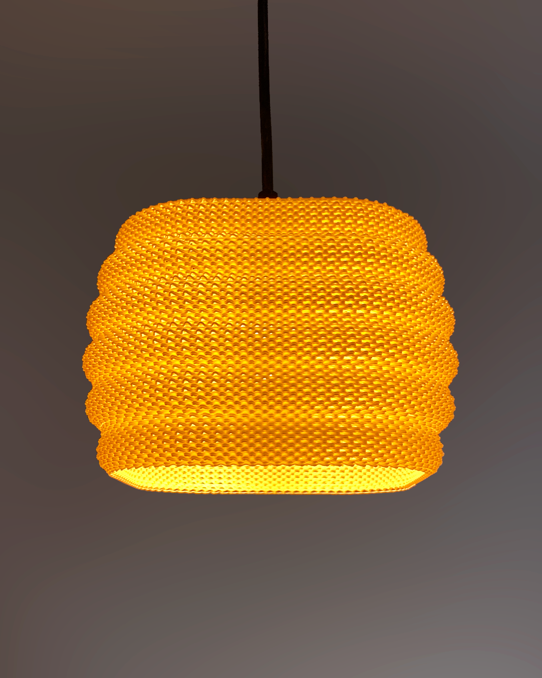 Daira Lampshade softly lit in orange, highlighting its modern woven pattern, ideal for enhancing home ambiance.