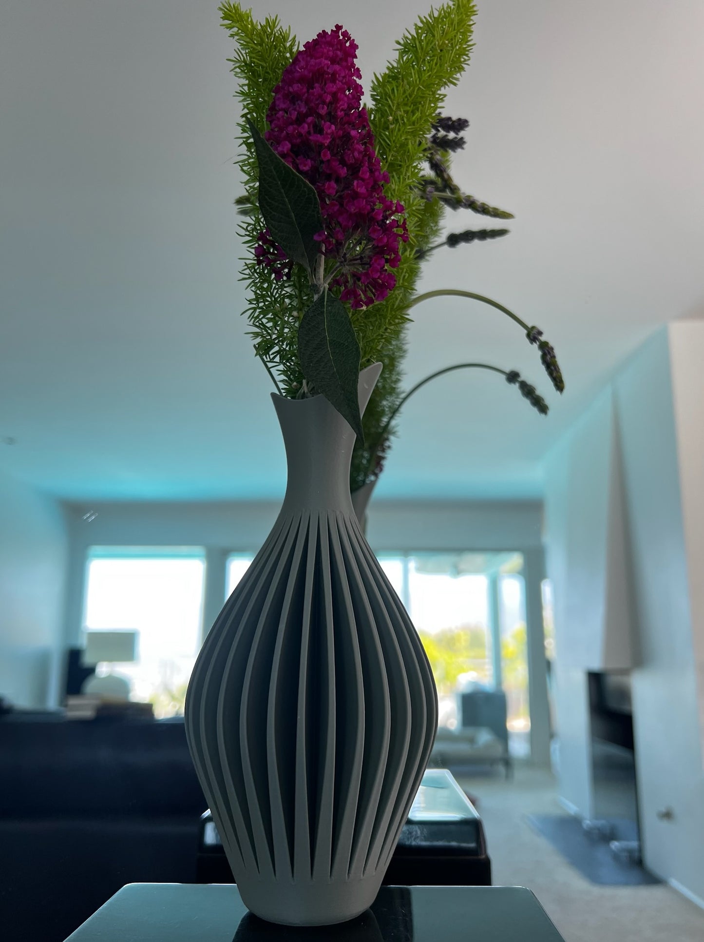 Elegant arrangement of flowers in a chic orange wall vase, showcased against a neutral background.