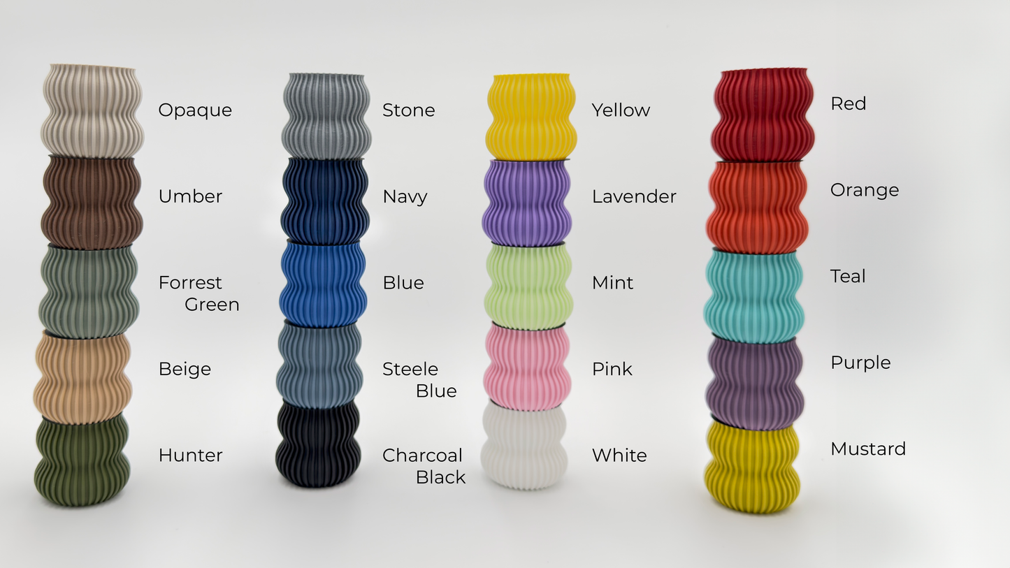 A stacked display of colorful ribbed wall vases in 20 matte shades, showcasing a wide range of decorative options.