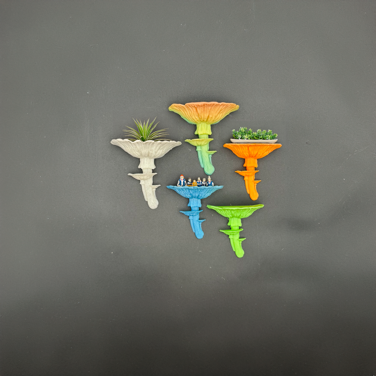 Group of vibrant Amanita mushroom floating shelves in different colors including orange, blue, and green, featuring mini plants and figurines for a fun decor touch.