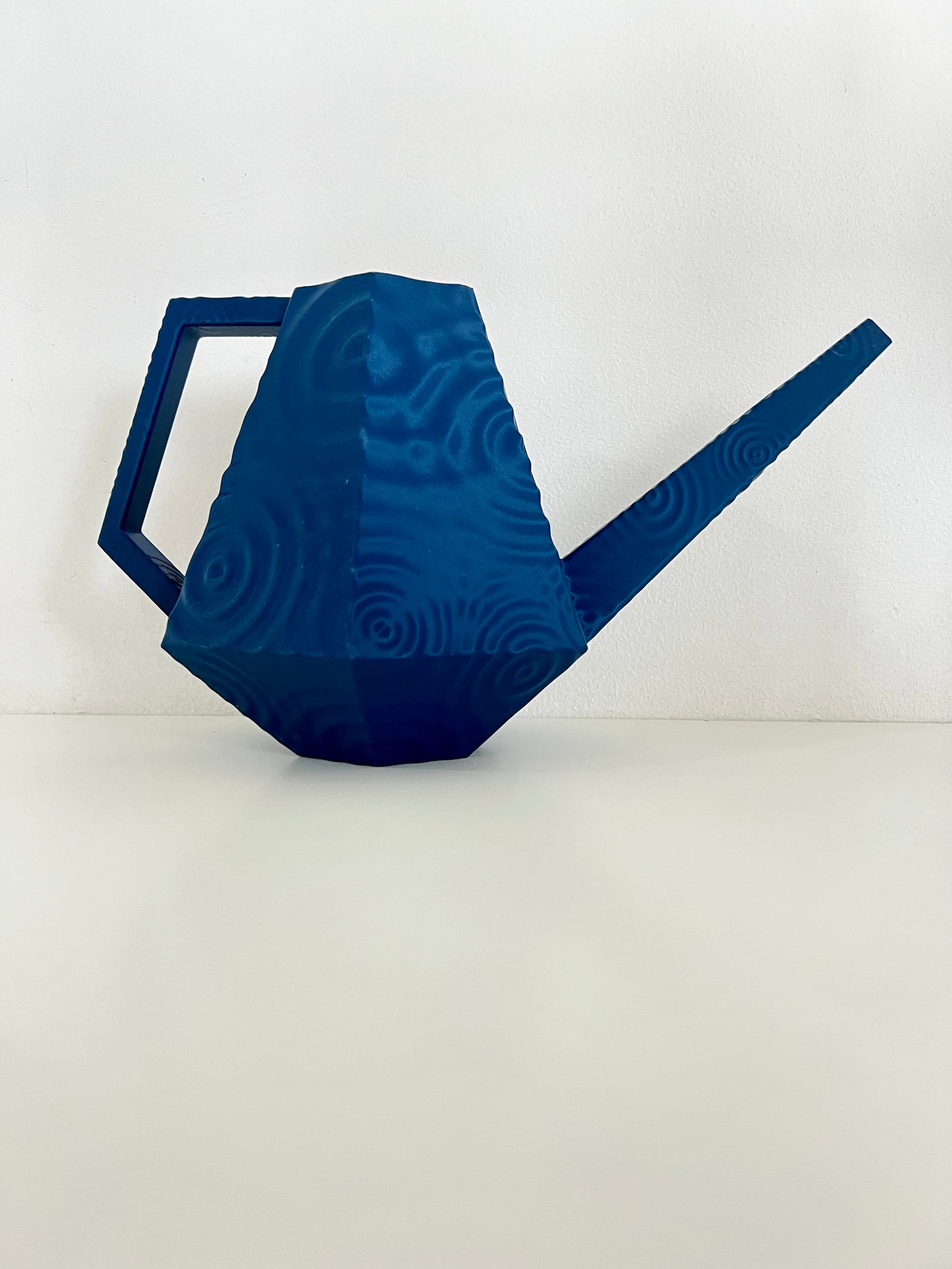 Stylish blue droplet watering can with a sculptural design and easy-pour spout on a white background, ideal for modern plant care.