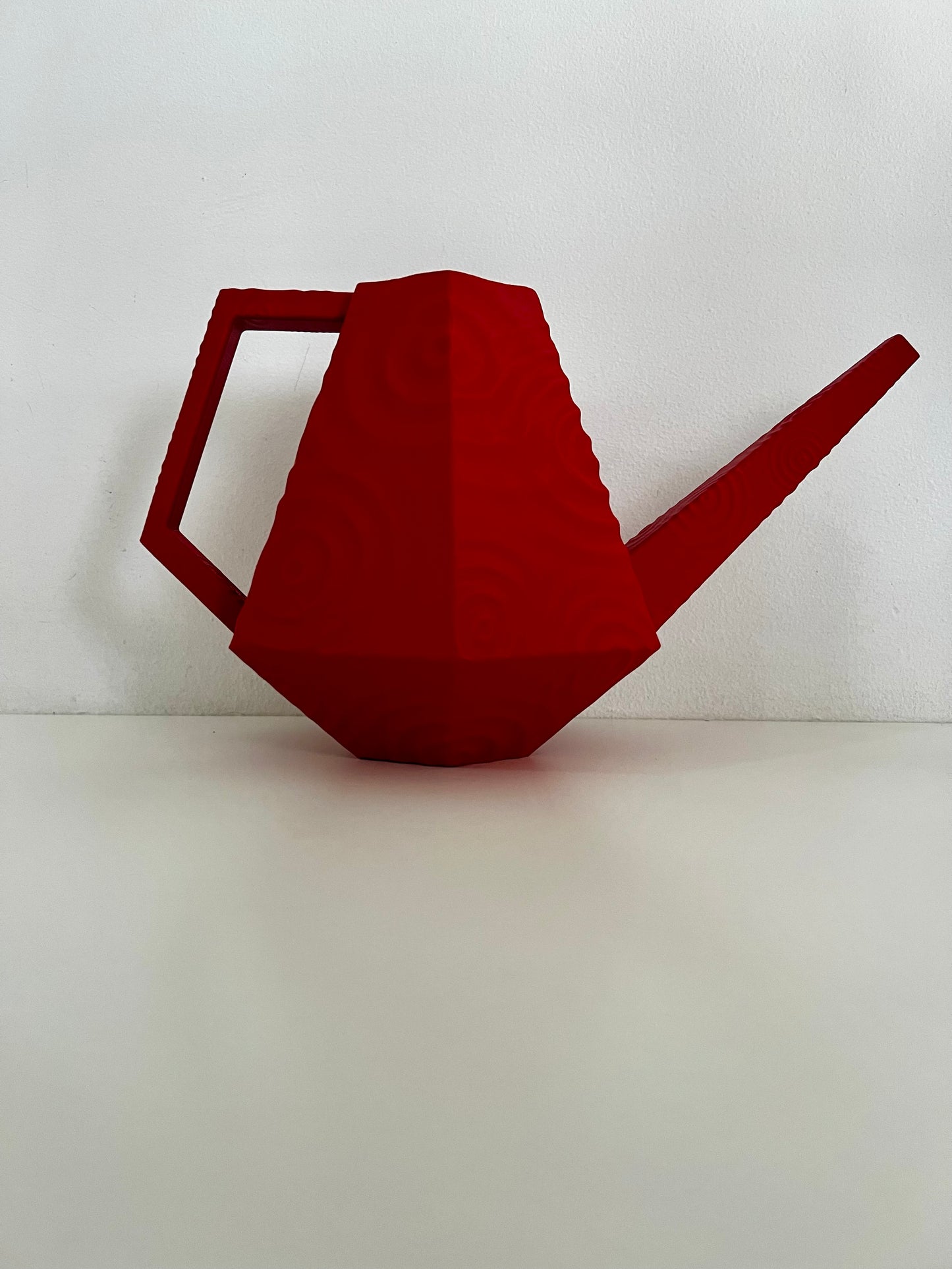 Vibrant red droplet watering can featuring a unique sculptural shape and easy-pour spout, perfect for watering indoor plants.