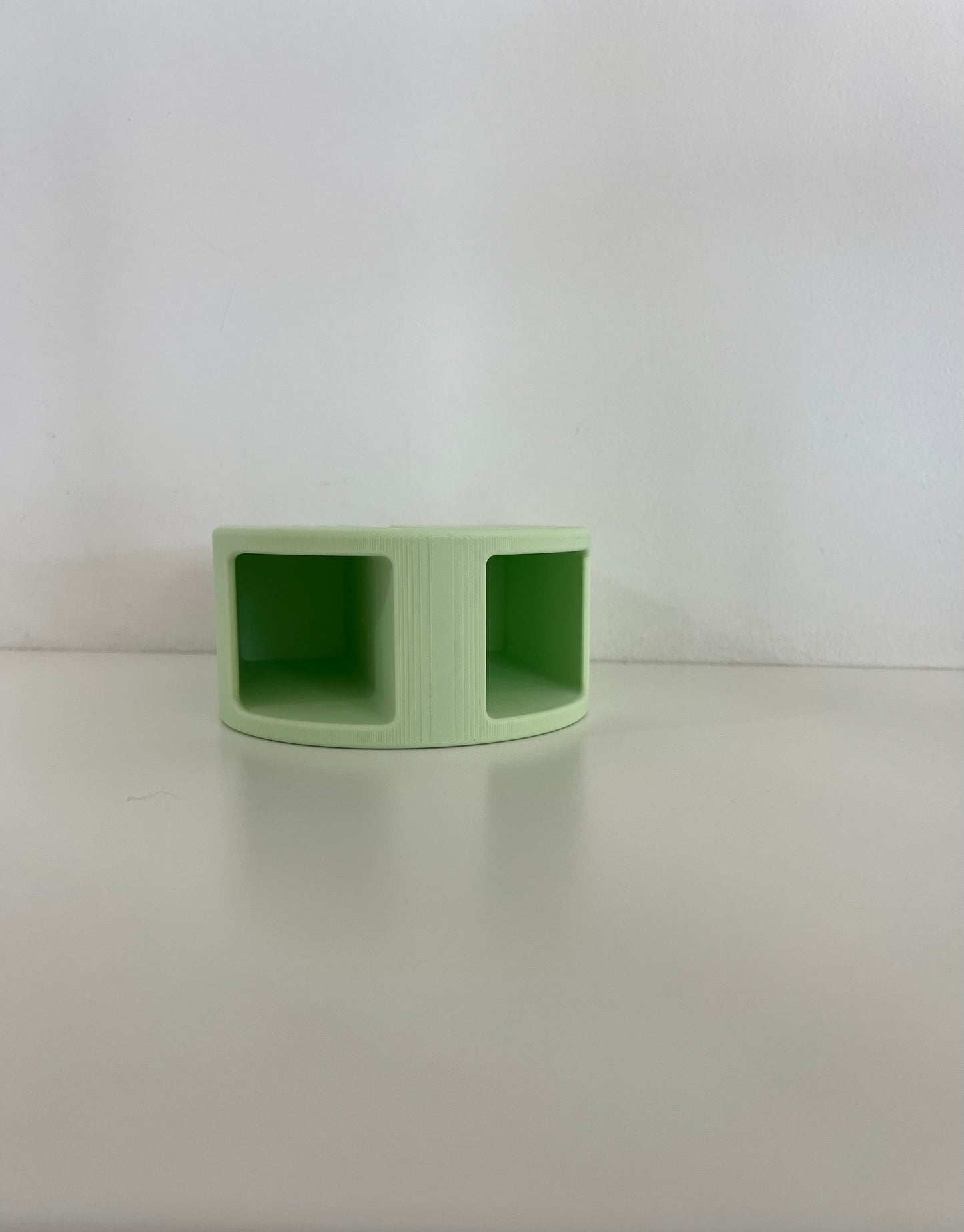 Compact green organizer with two sections, ideal for keeping stationery or personal items organized on a desk.