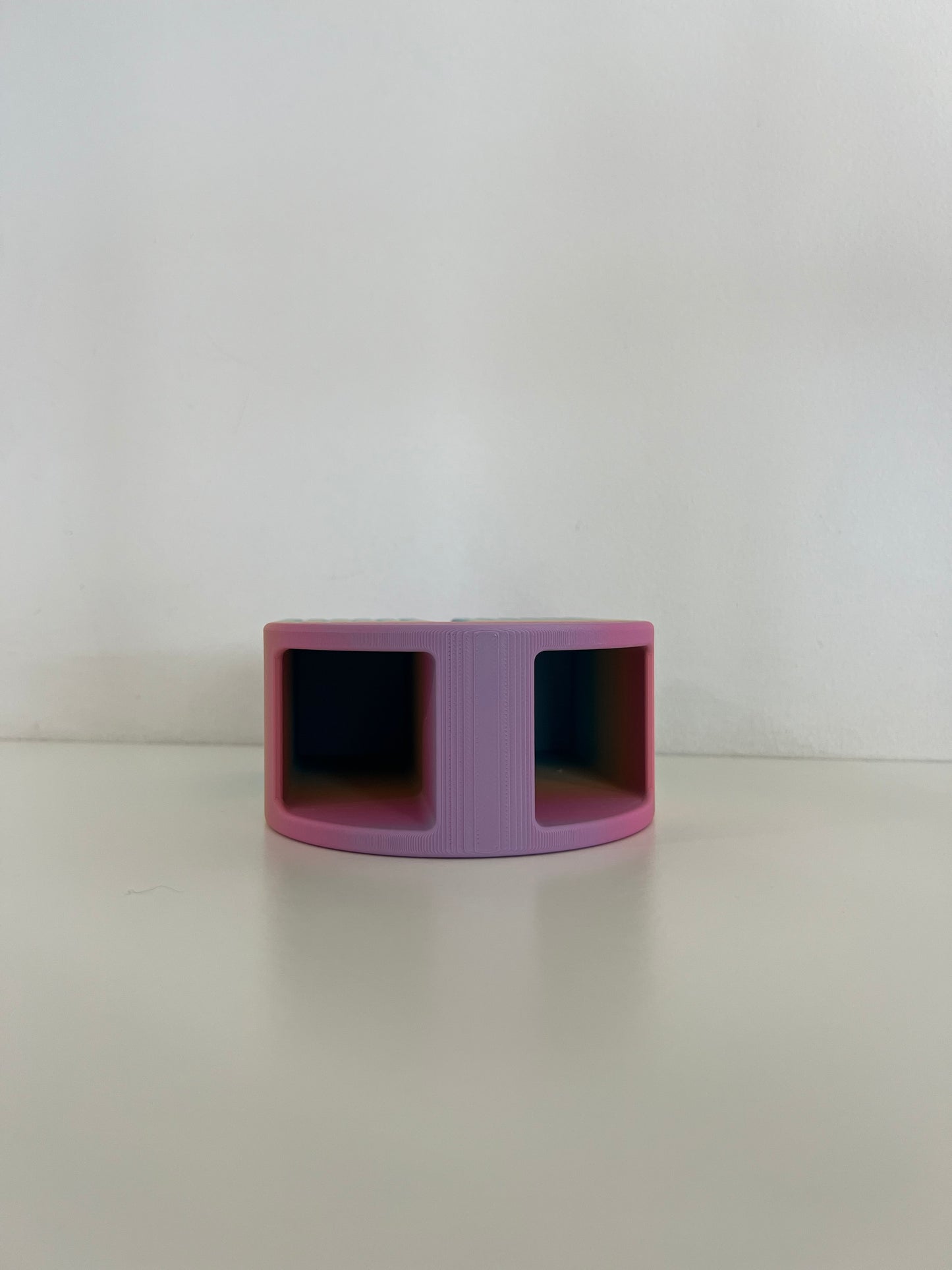 Unique pink organizer with two compartments, designed to hold pens and small essentials on a tidy workspace.