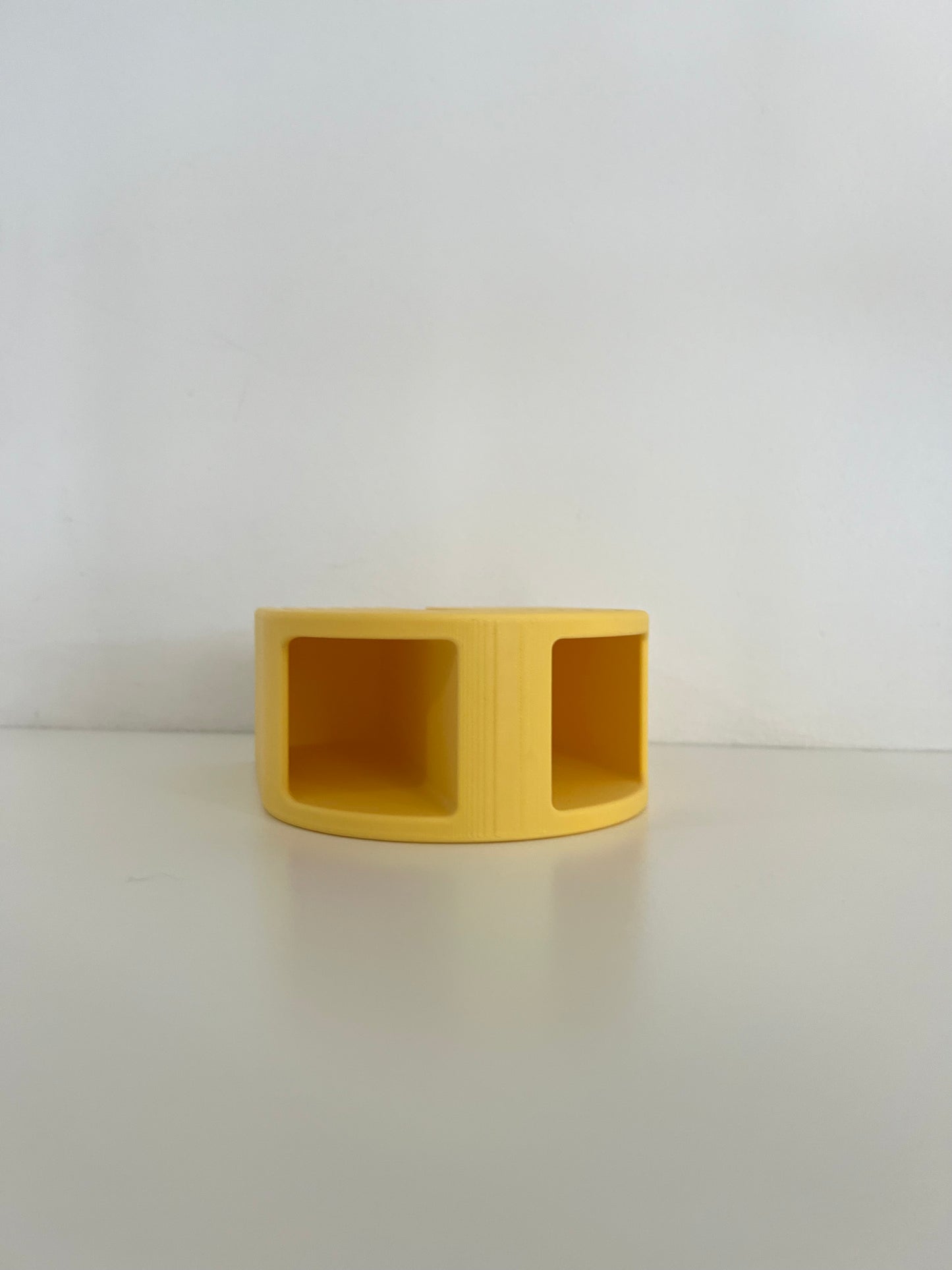 Compact yellow organizer with two sections, suitable for holding office supplies or small decorative items.