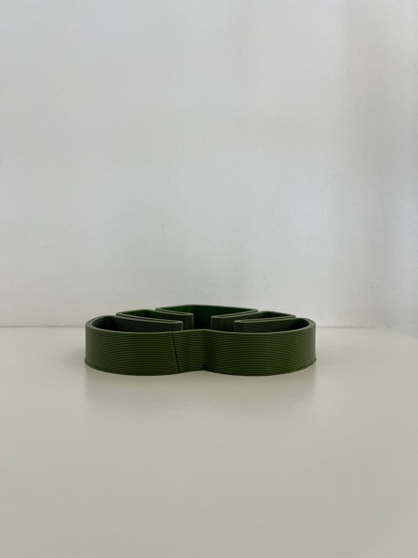 Side view of a green Monstera leaf tray designed for stylish organization of small accessories.