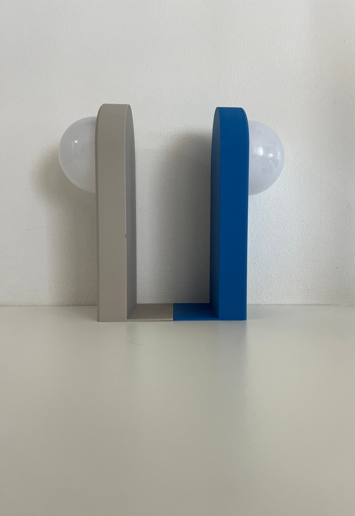 Front view of a minimalist lighted bookend in blue and gray colors, showcasing its modern design.