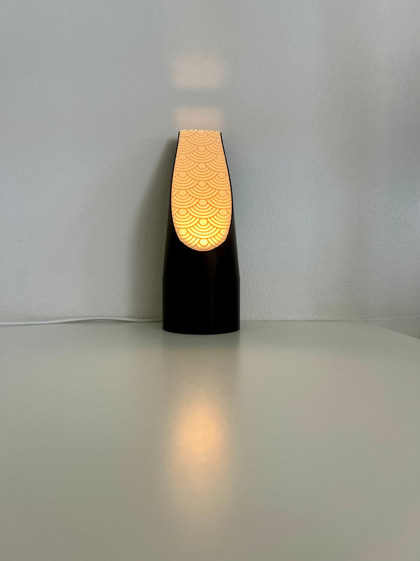 Stylish black mood light illuminating with a soft orange hue through a patterned diffuser, ideal for creating a cozy atmosphere.