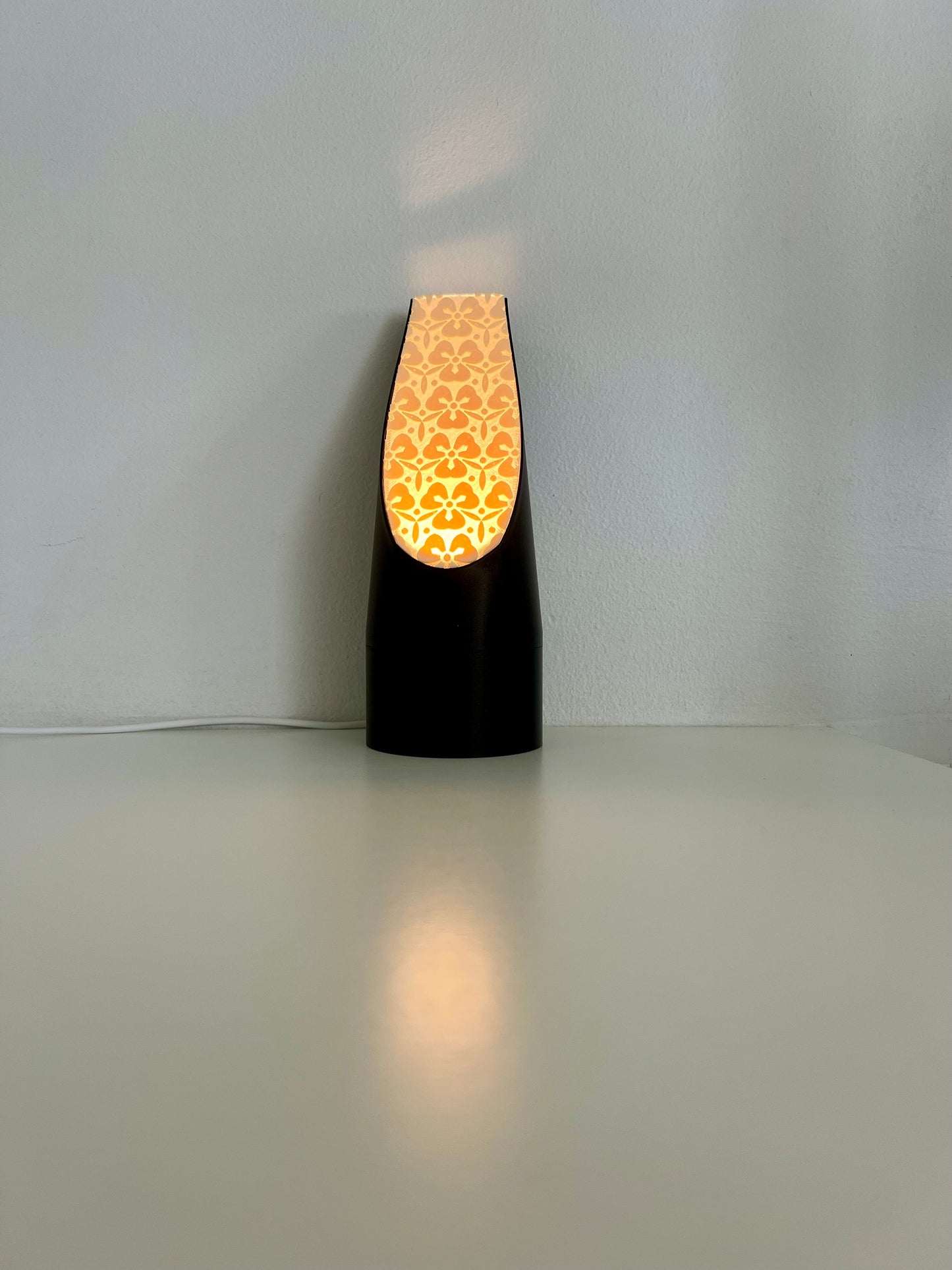 Elegant black mood light featuring a unique floral-patterned diffuser, casting a warm glow and adding charm to your decor.