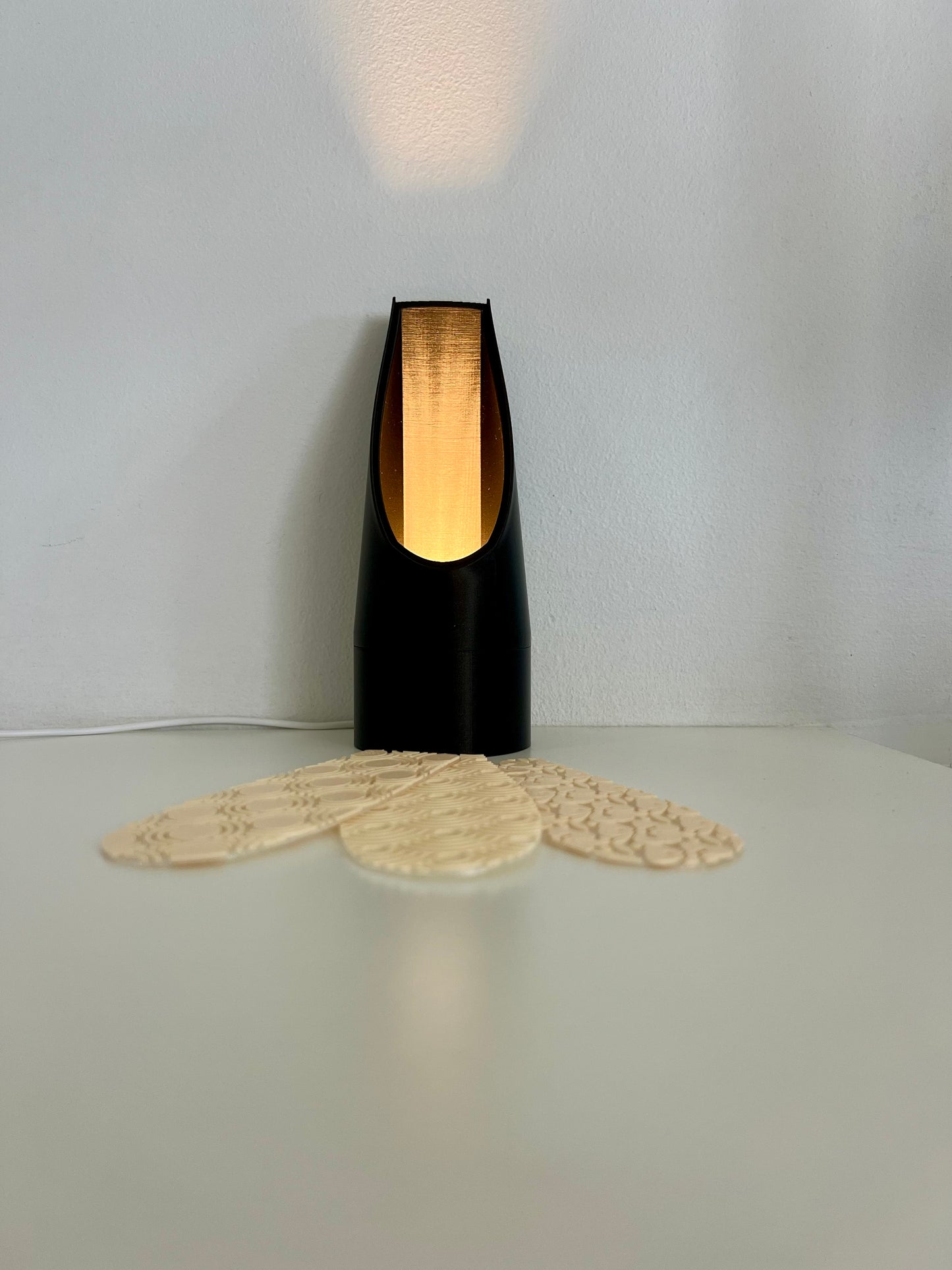 Black mood light with a golden reflector, paired with stylish patterned bookmarks, ideal for a chic reading experience.