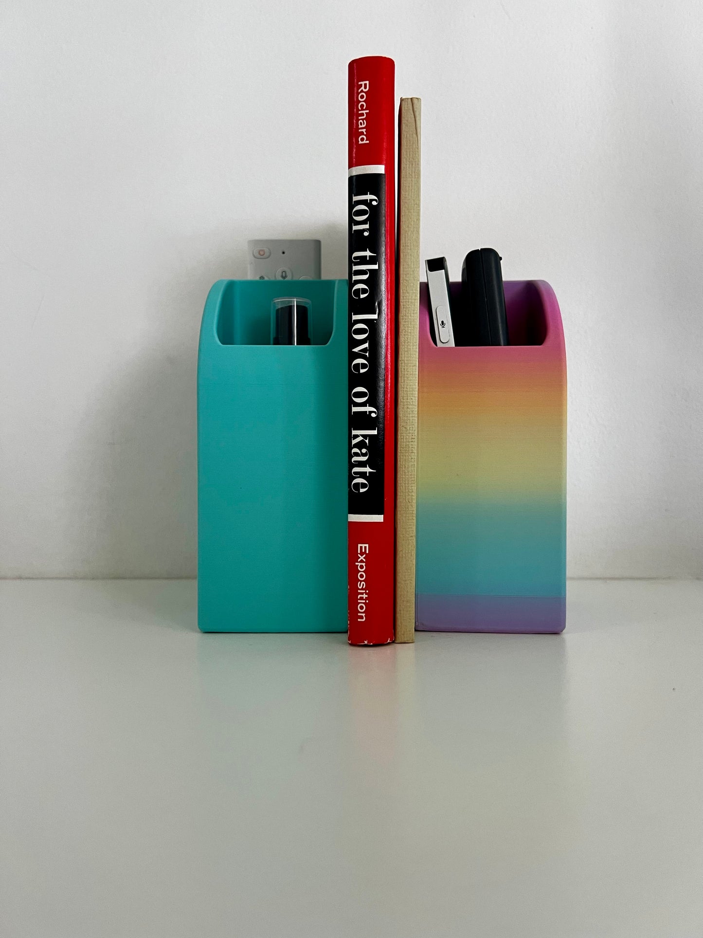 Chic turquoise organizer on a desk holding a remote control with a book in the background, adding a pop of color to the workspace.