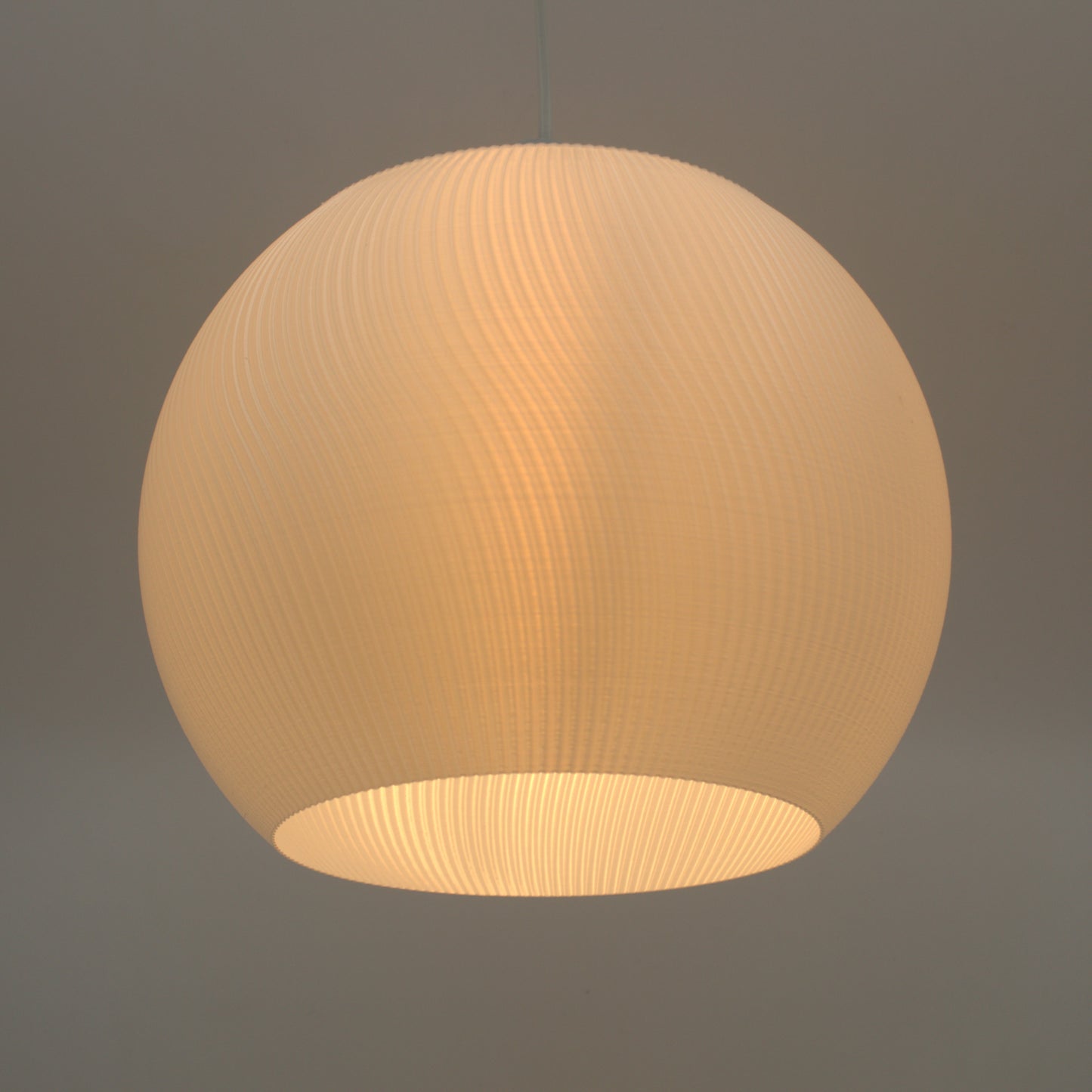 Illuminated round lampshade in a warm, soft color, showcasing a unique textural design for stylish lighting.