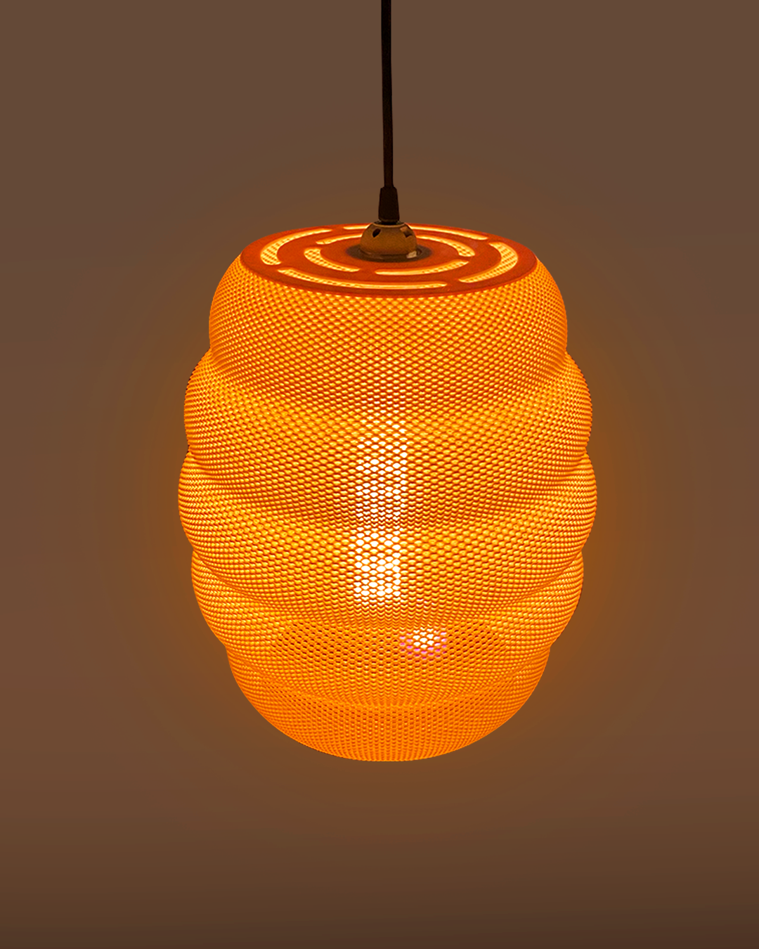 A glowing orange beehive-shaped pendant light hangs from a black cord against a warm-toned background.