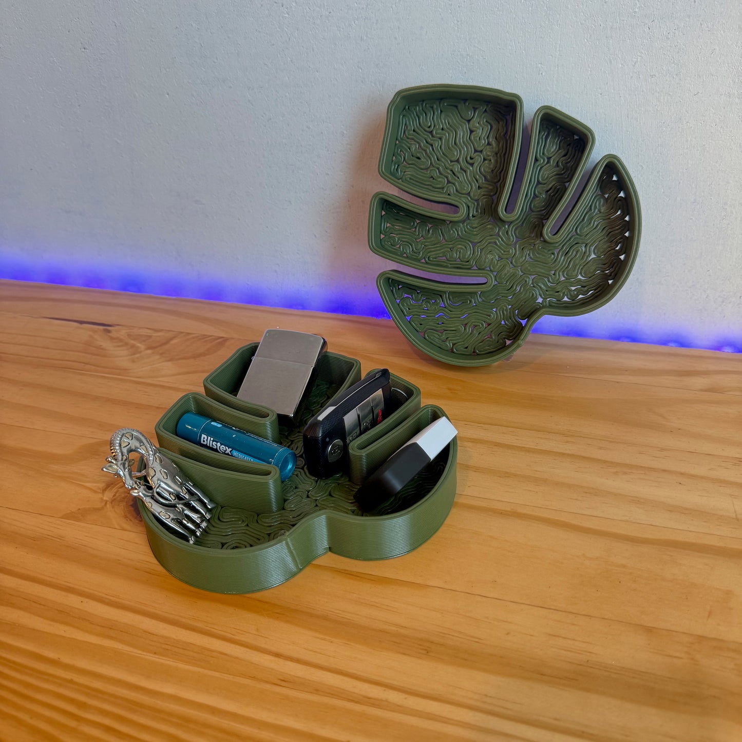 Monstera leaf tray displaying everyday items like keys and lip balm in a stylish, organized manner.