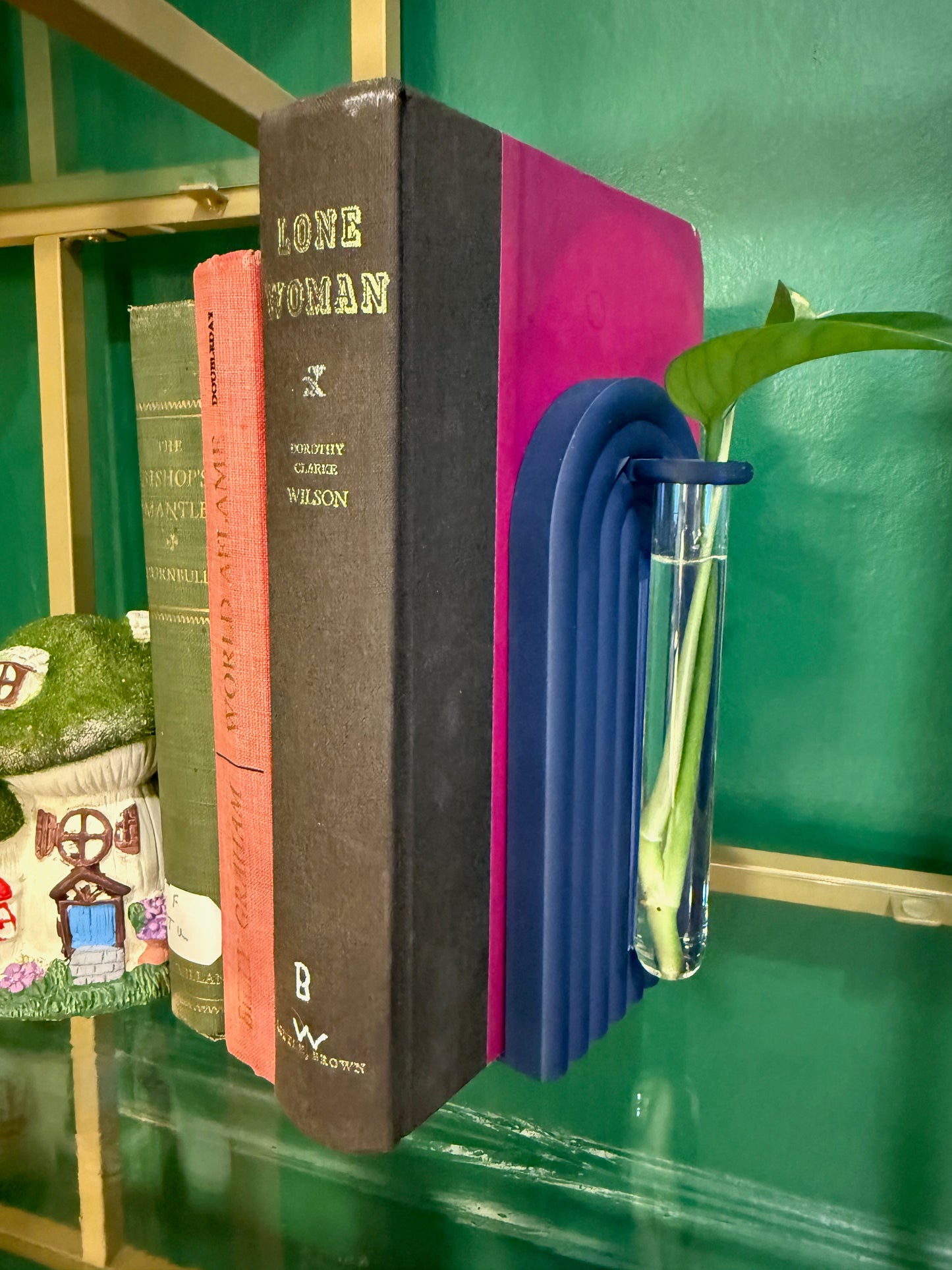 Contemporary propagation bookend featuring colorful flowers, positioned next to rich blue literature.