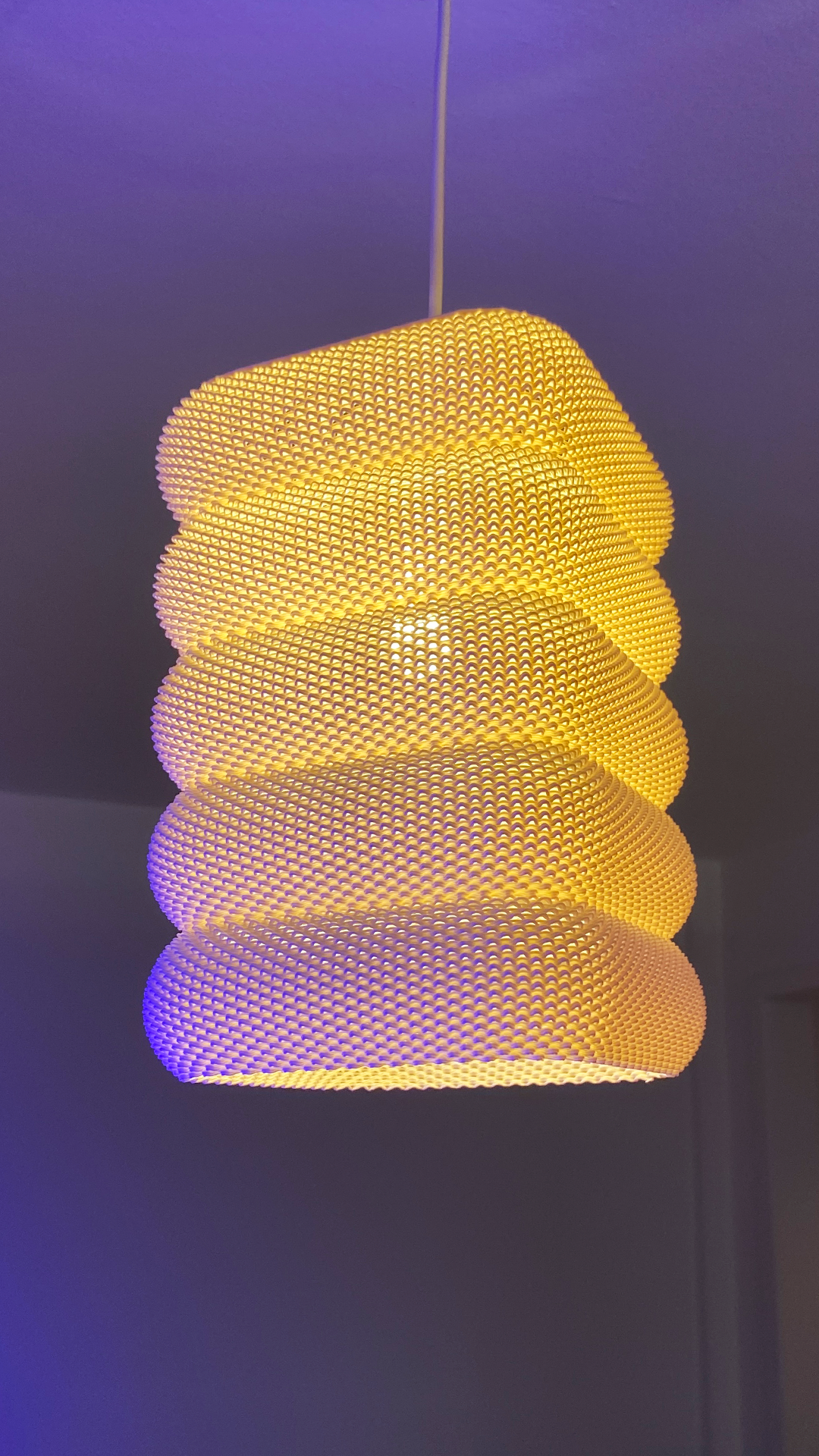 SARA Table Lamp designed as a pendant light, featuring warm yellow hues with an artistic layering effect, suspended from the ceiling.