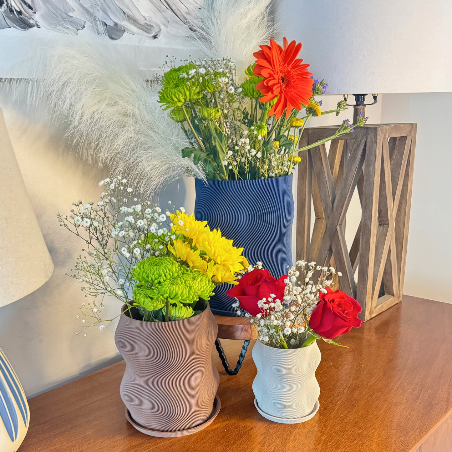 Trendy Curvy Modern Planter with drainage and under plate, enhancing a cozy indoor plant setup.