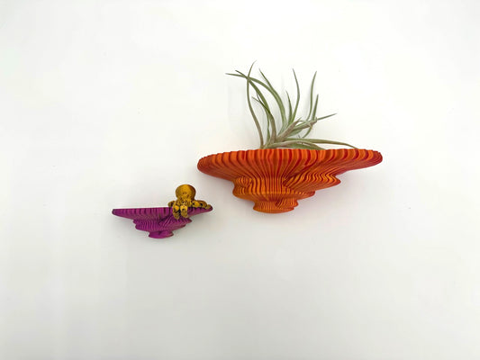 Colorful shimmering Tinder fungus themed floating shelves in orange and purple, featuring air plants for an enchanting home decor accent.