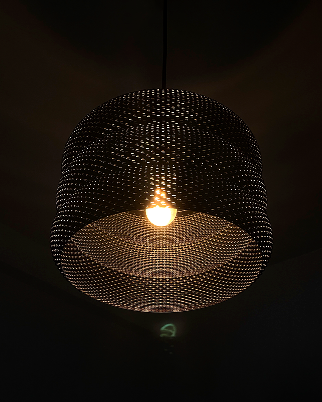 Mara Lampshade glowing warmly in a dimly lit room, showcasing its unique design and captivating light effects.