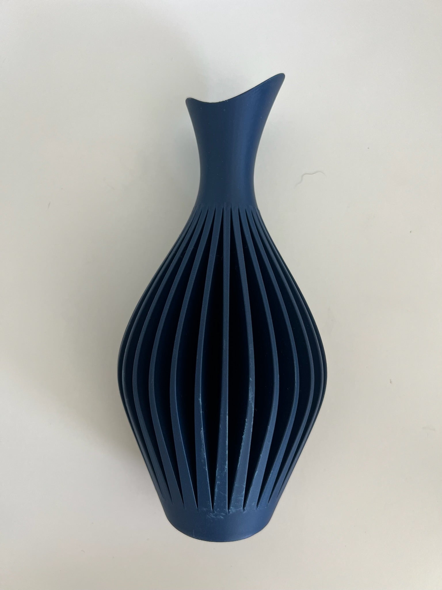 Striking navy blue wall vase showcasing floral decor, adding style to a minimalist space.