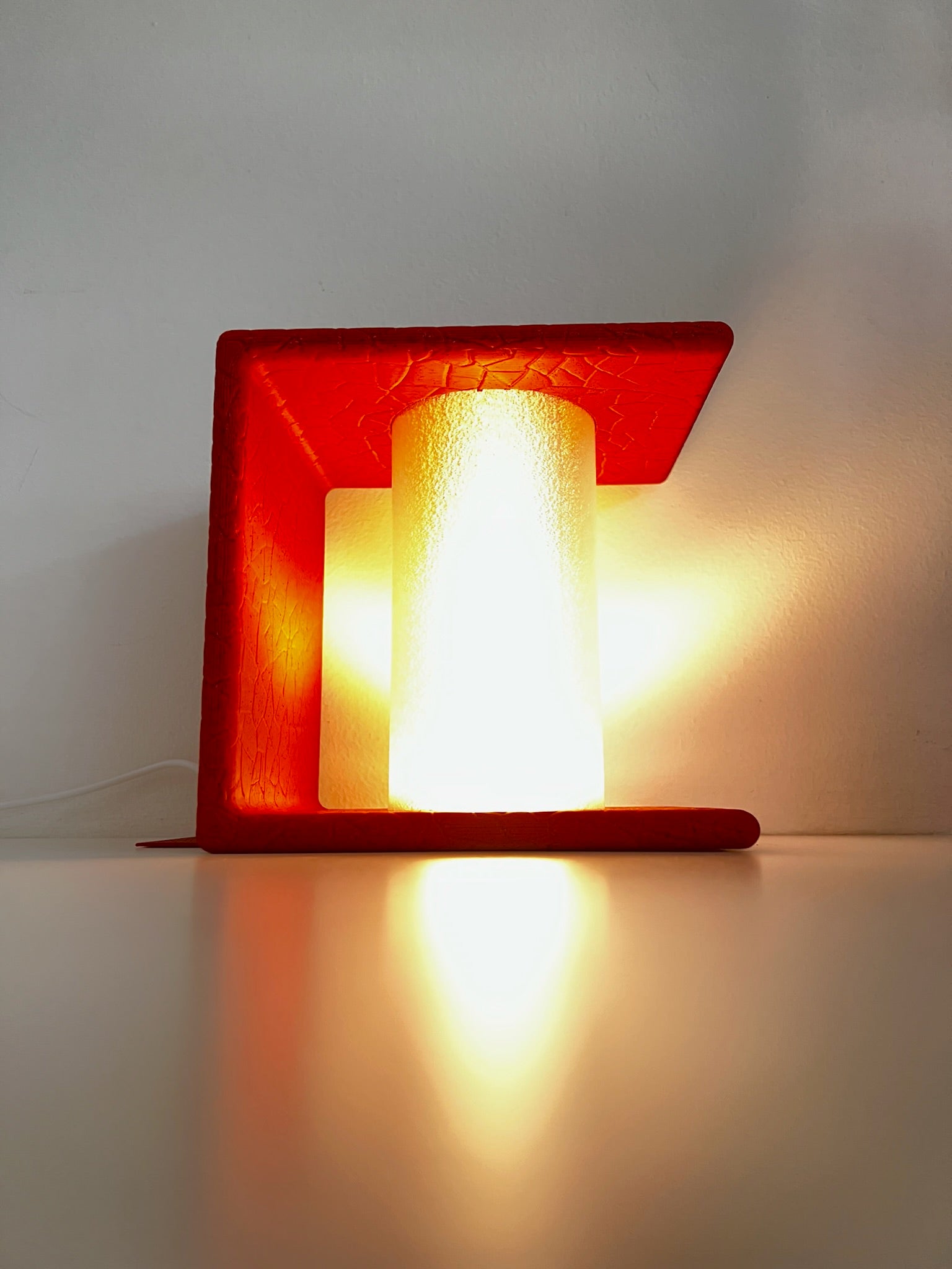 Visually striking red Ancient Marble Lighted Bookend glowing softly, creating a welcoming atmosphere with books set nearby.