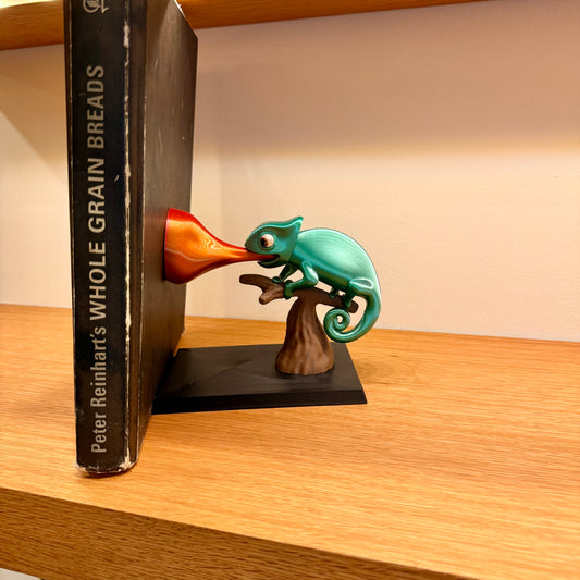 Bookend with a chameleon design on a wooden surface