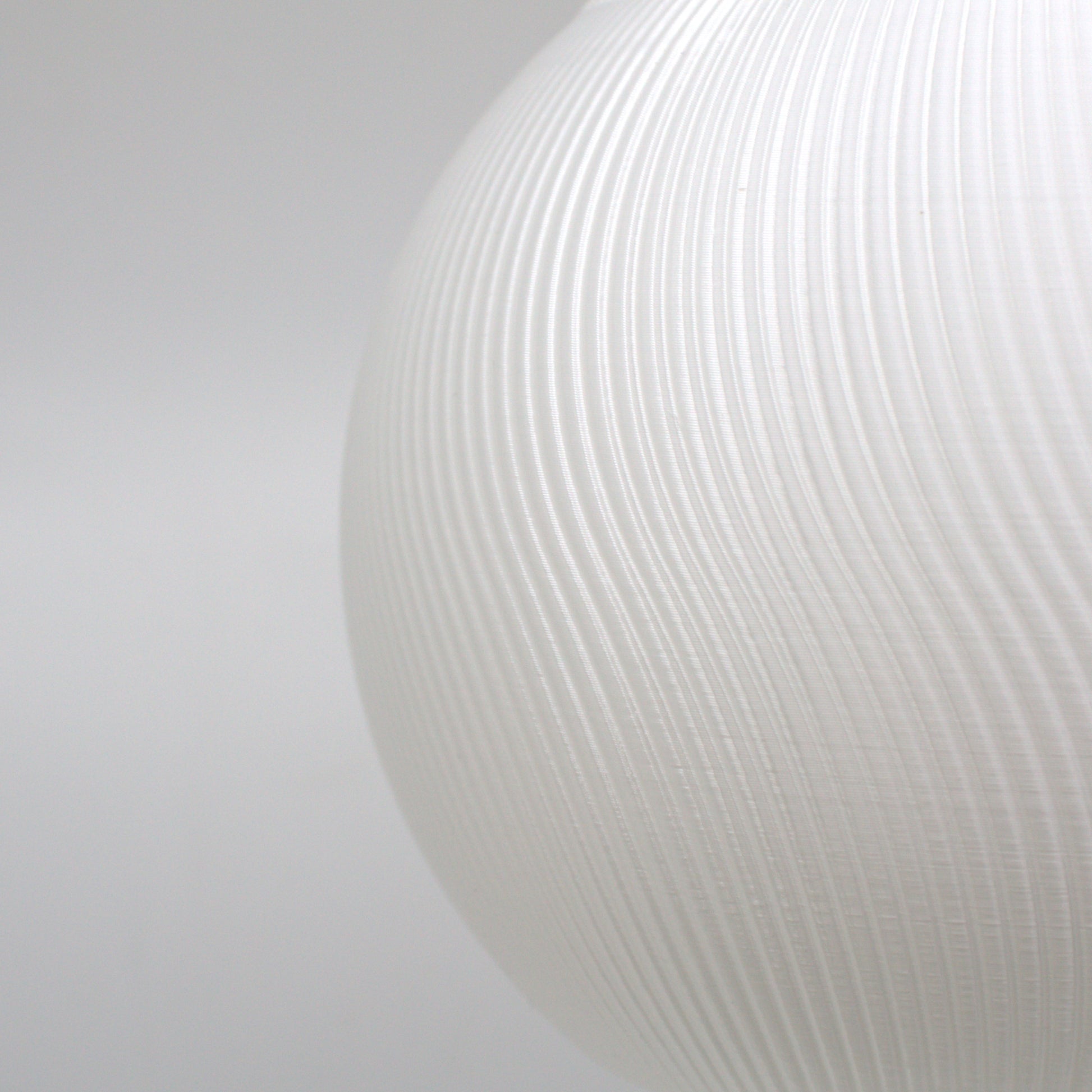 Detailed view of a textured white lampshade, highlighting its modern aesthetic and light-diffusing qualities.