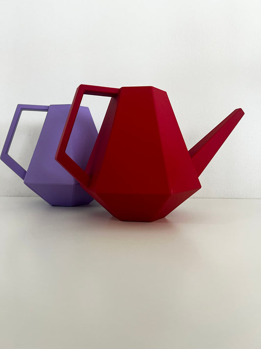 Side view of a purple and a red geometric watering can, showcasing their stylish design and colors.