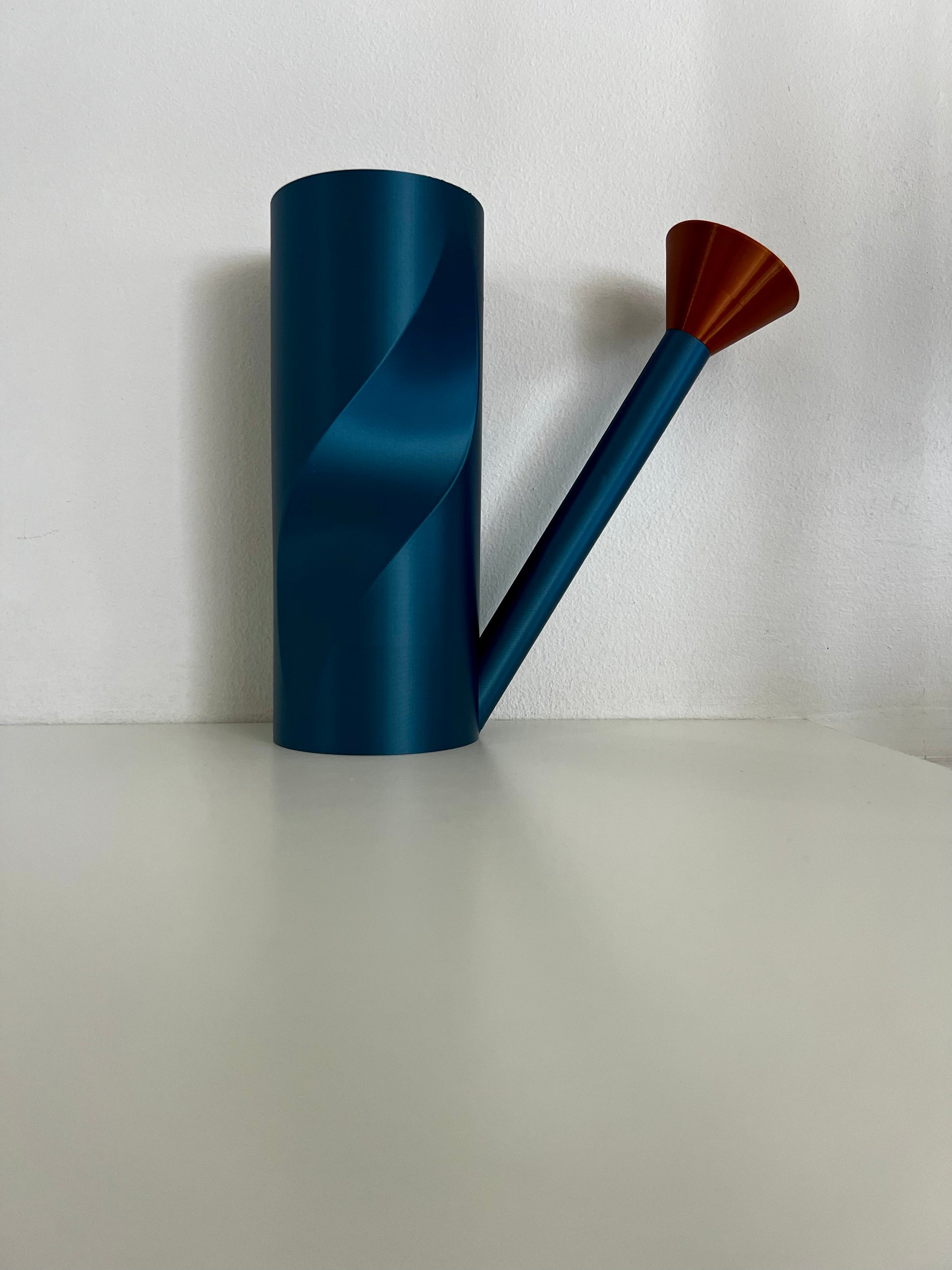 An elegant blue watering can next to a pair of captivating copper spouts, showcasing their innovative design.