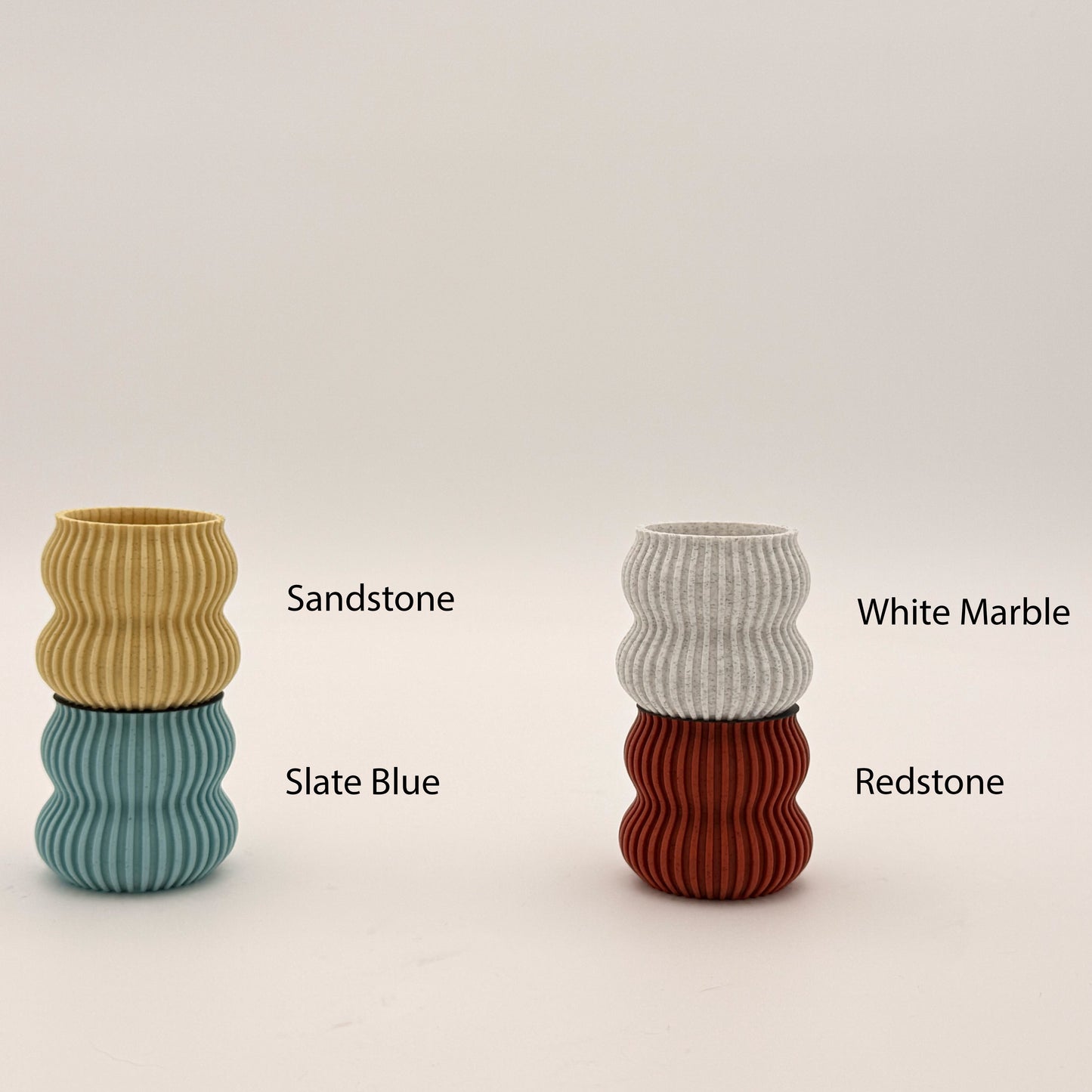 Colorful Moai Bookend materials showcasing Sandstone, Slate Blue, White Marble, and Redstone options, highlighting the sculptural design perfect for stylish bookshelves.