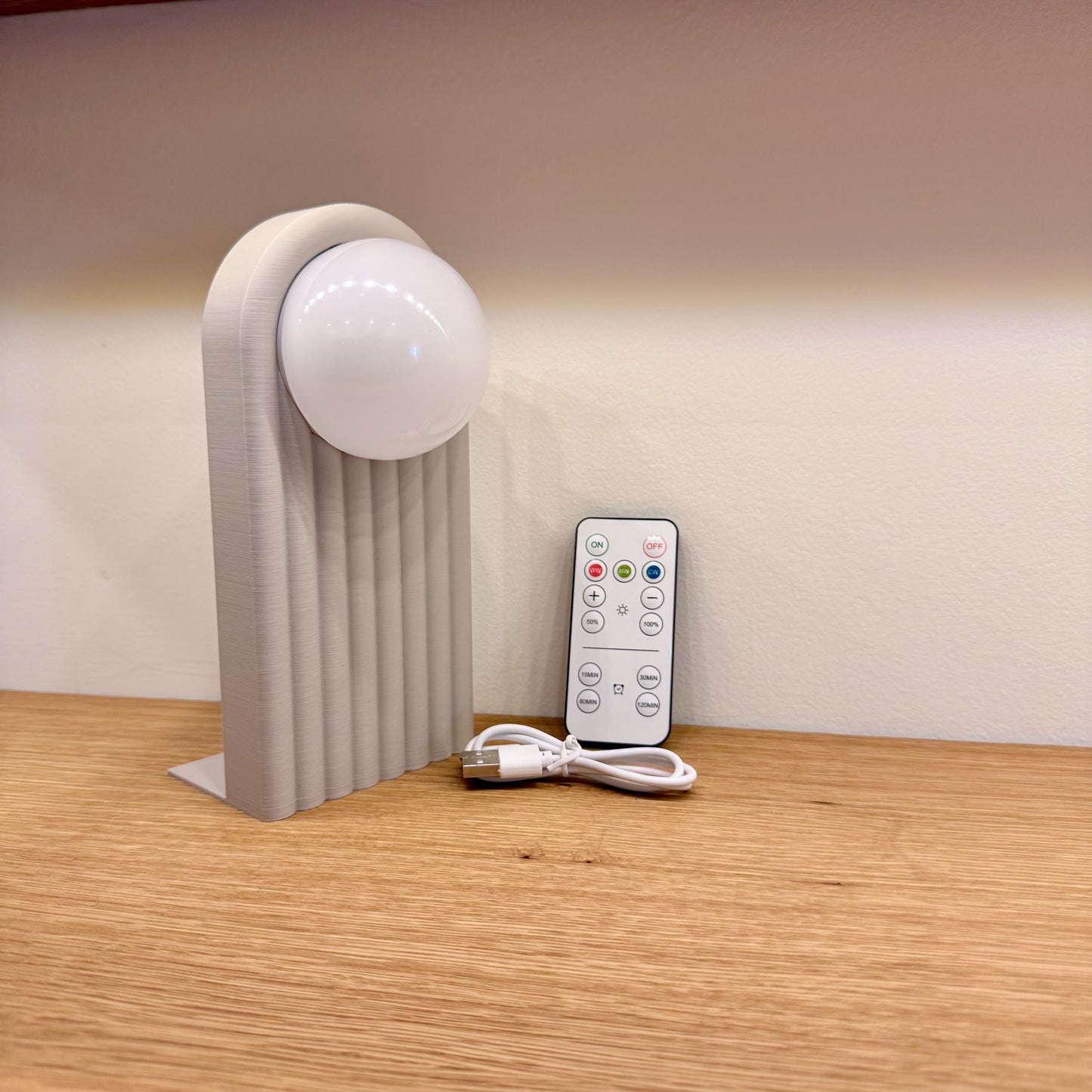 Retro Chic Lighted Bookend for Kids Room or Library showing a lighted bookend in white next to the charging cable and remote control, perfect for stylish illumination.