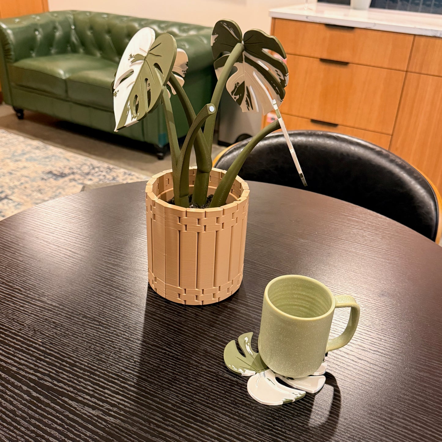 Variegated Monstera Coaster Set and a green mug complementing a chic living room decor with a rustic vibe.